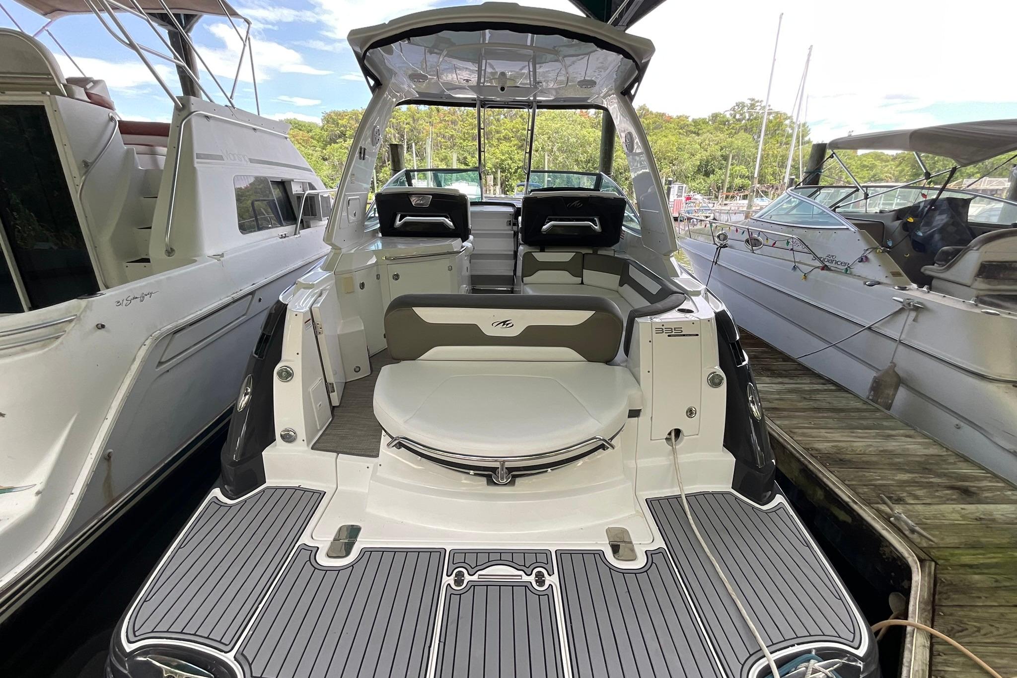 2019 Monterey 335 Sport Yacht docked, showcasing spacious deck and seating area.