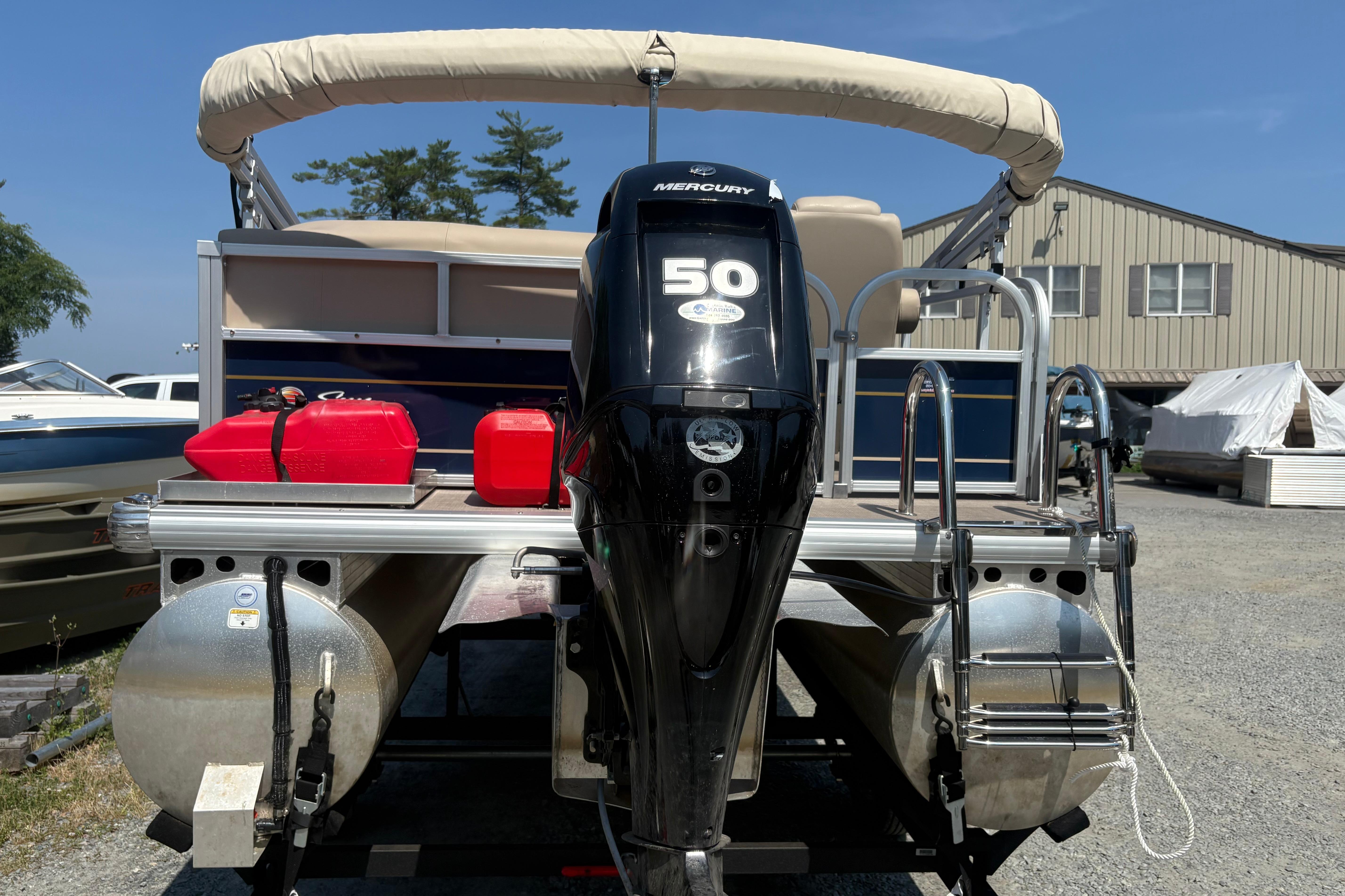 2024 Sun Tracker Bass Buggy 16 DLX pontoon boat with Mercury 50 engine, docked outdoors.