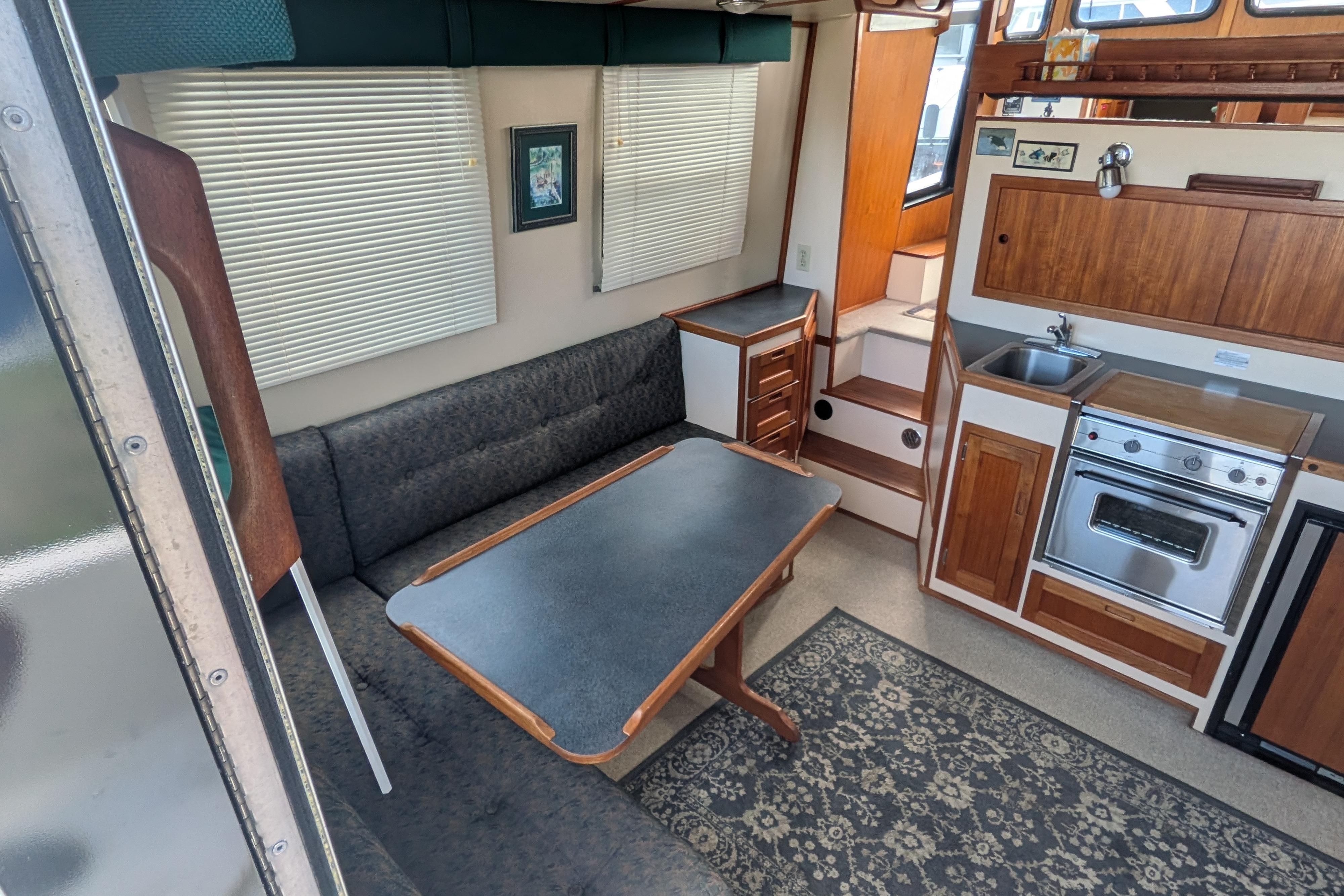 Interior of a 1998 Nordic Tug 32, featuring a cozy dining area and compact kitchen.