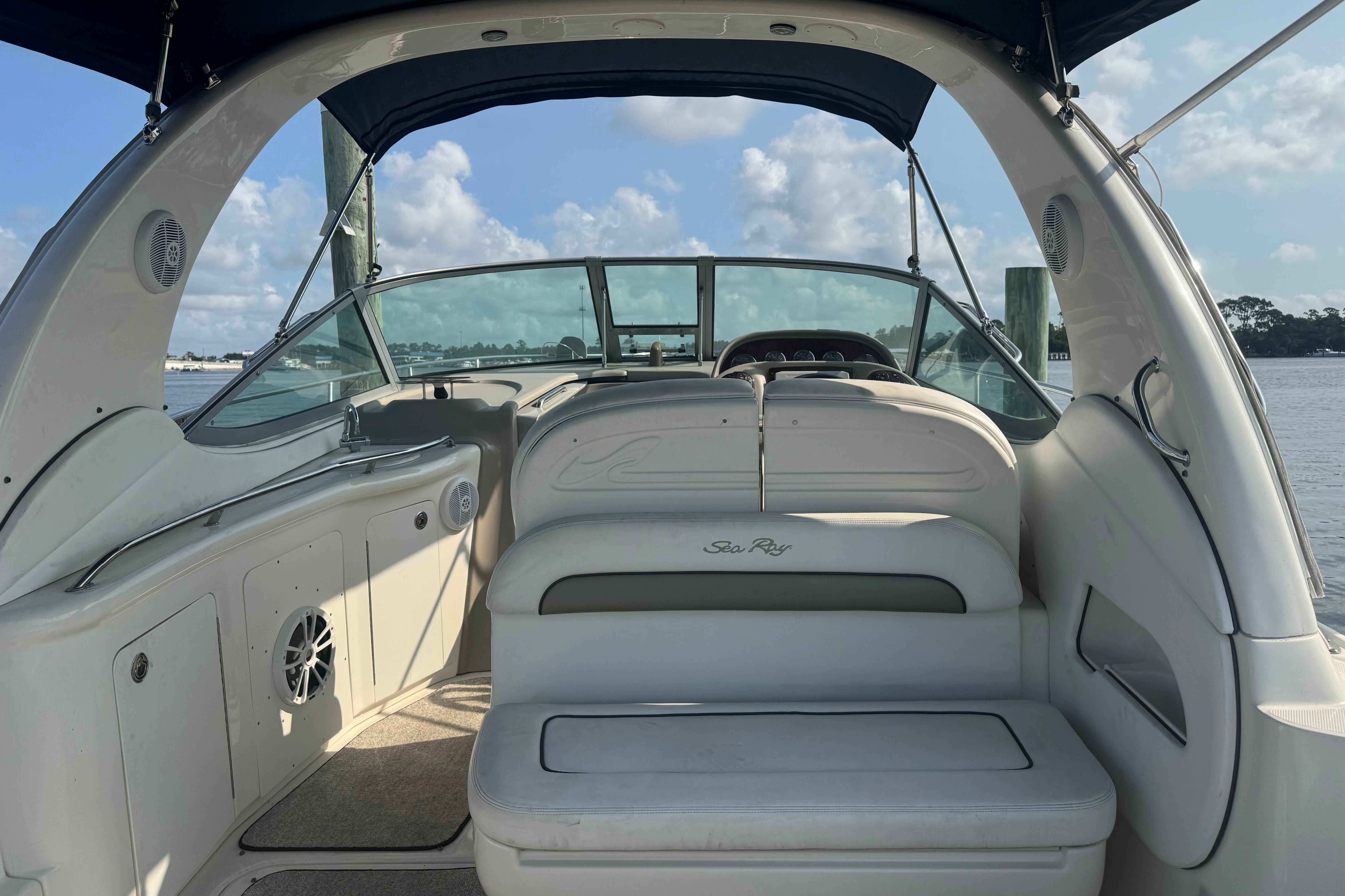 2006 Sea Ray 300 Sundancer boat interior with seating, docked by the water.
