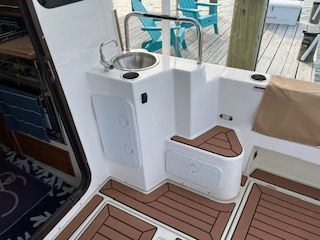 Ranger Tugs R 31 LE 2023 with teak flooring and stainless steel sink.