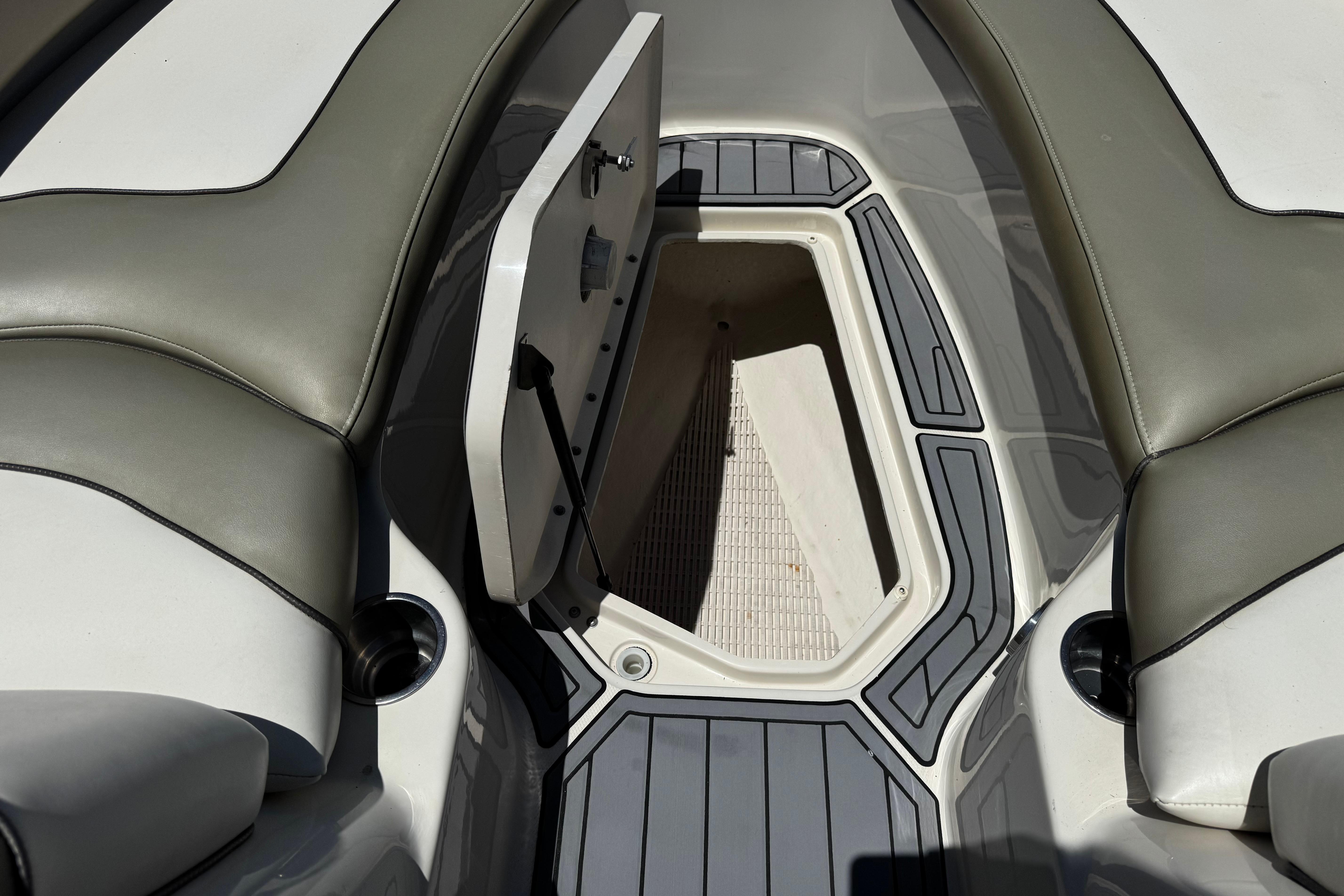 2007 Sea Ray 240 Sundeck interior storage compartment with open hatch and cushioned seating.