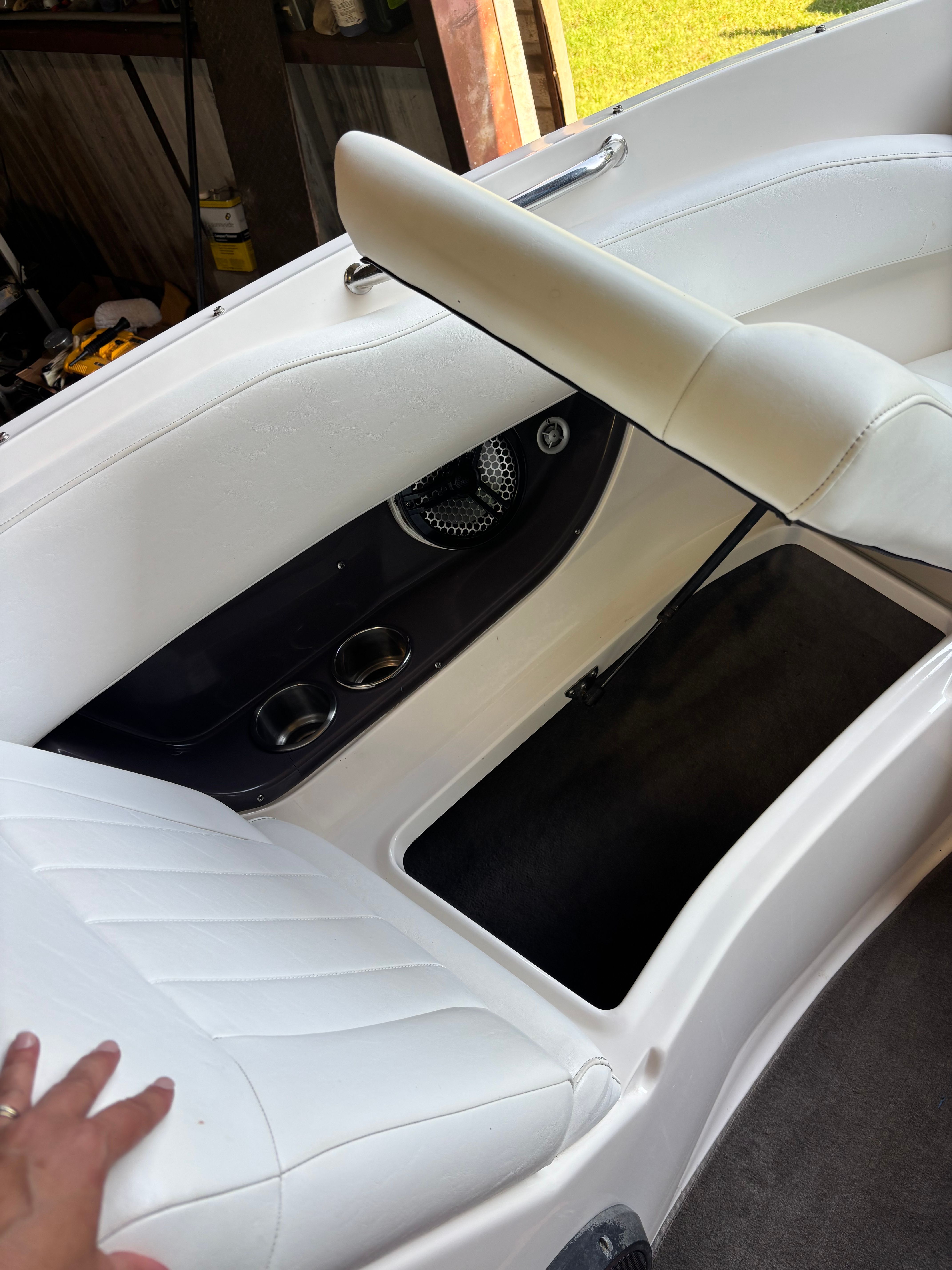 Interior view of a 2006 Regal 2200 Bowrider with white upholstery and storage space.
