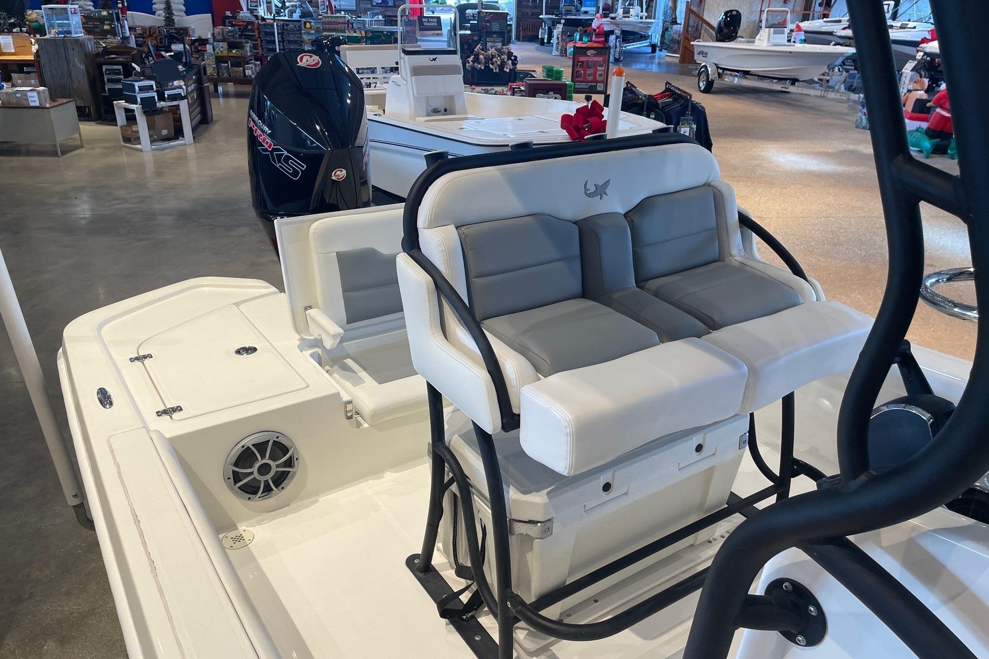 2026 Mako 24 APEX boat interior with seating and motor in showroom.