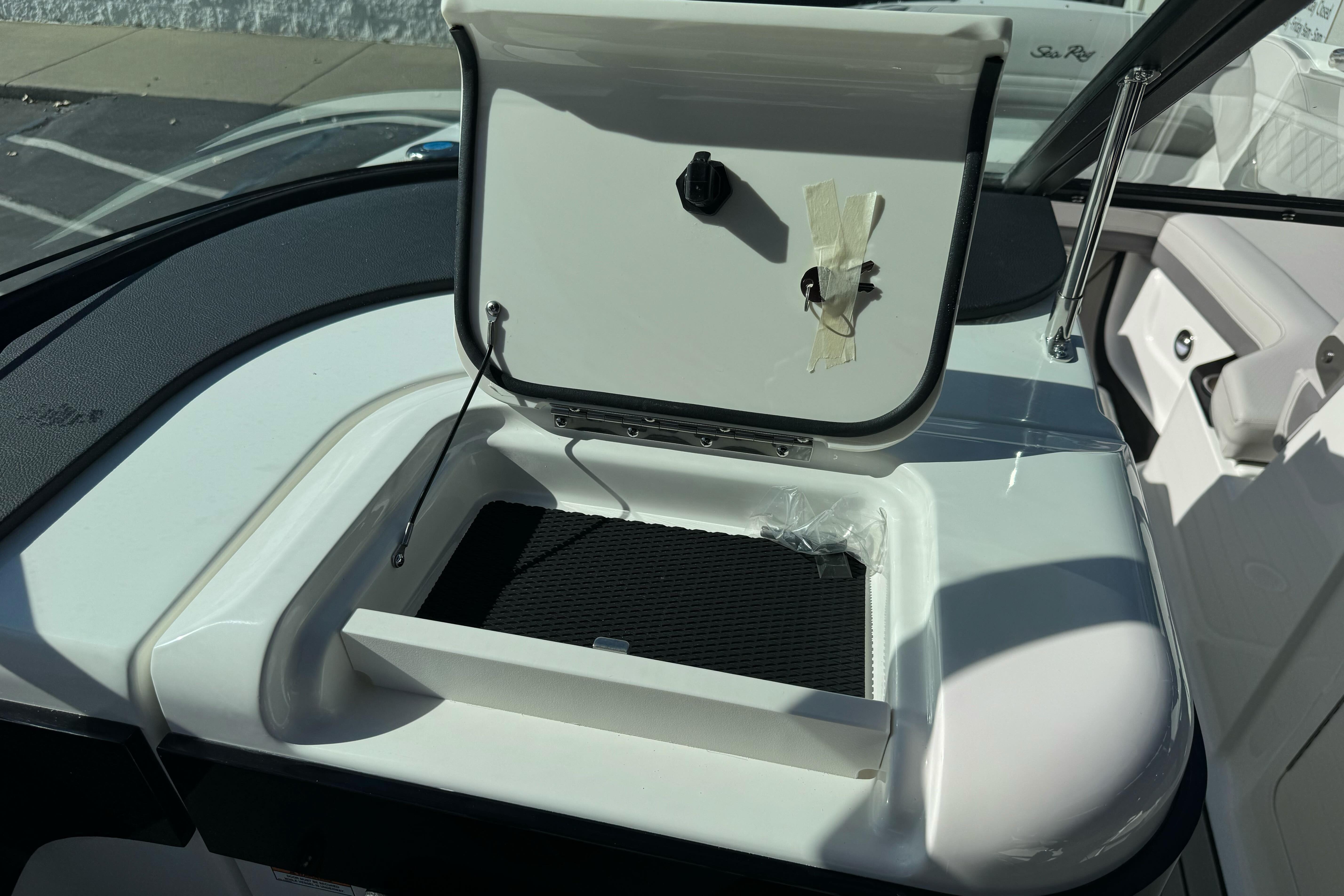 2026 Sea Ray SLX 260 boat storage compartment with open lid, showcasing interior details.