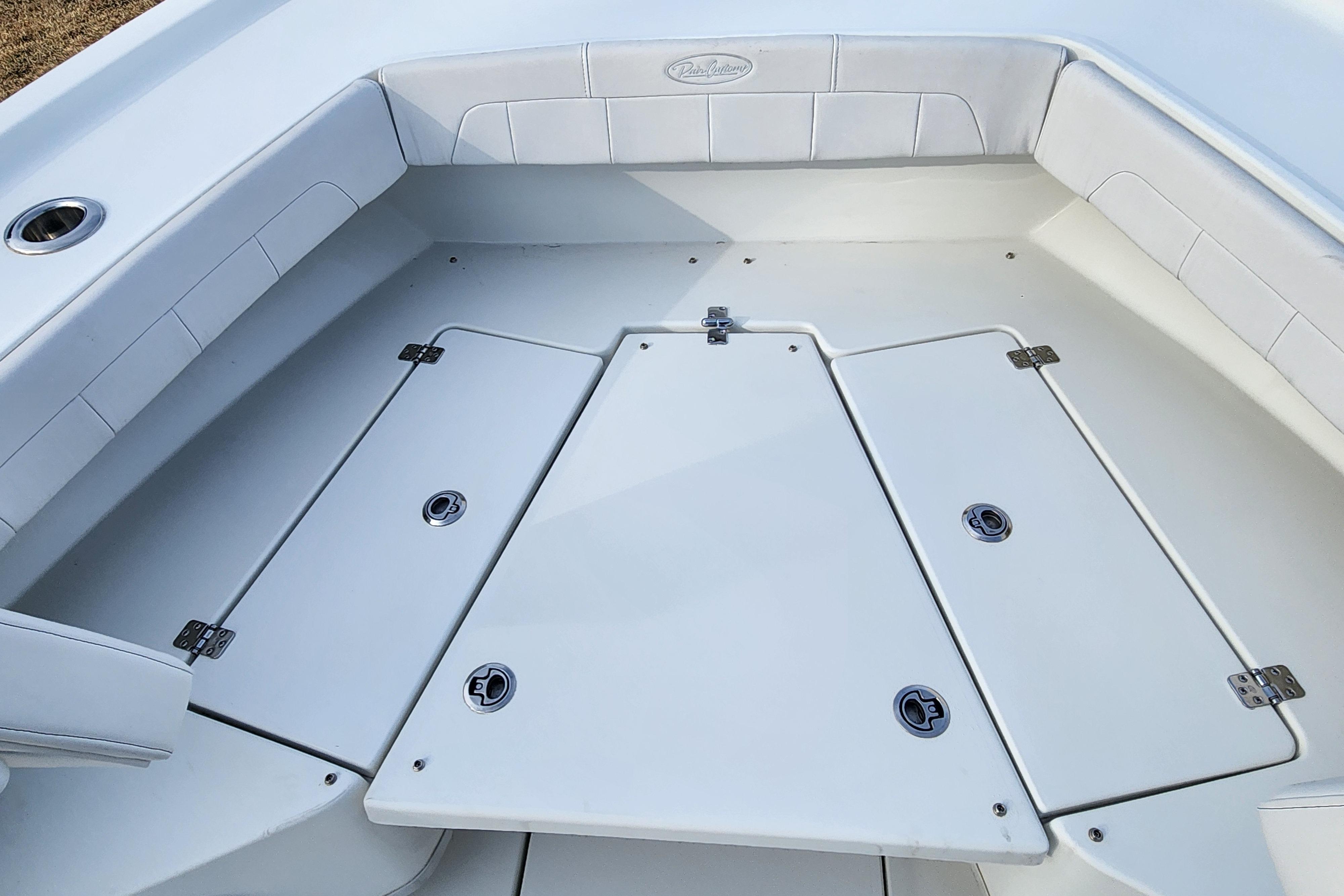 2024 Pair Customs 27 CC boat interior with white cushioned seating and storage compartments.