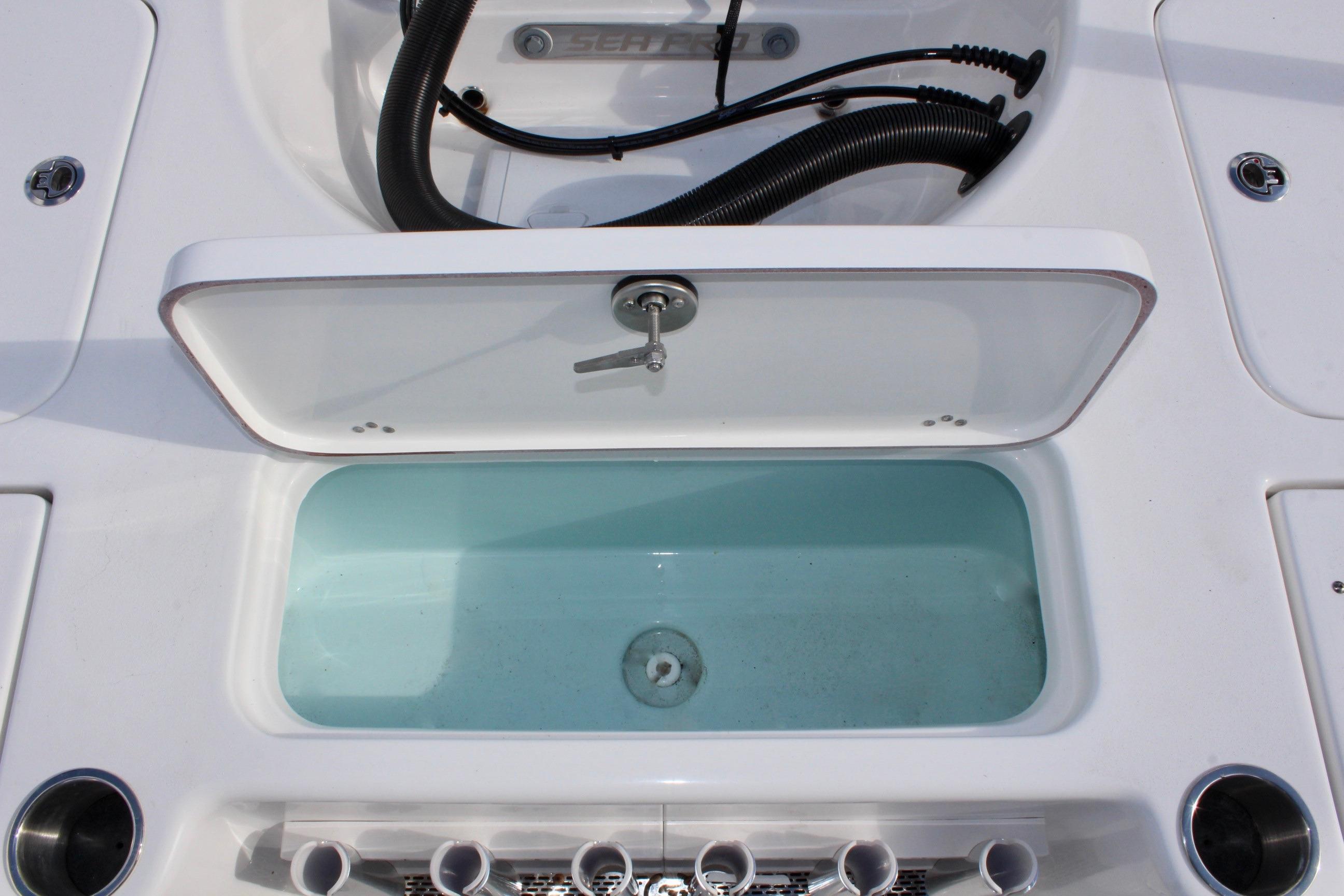 Livewell compartment on a 2025 Sea Pro 230 Bay boat, featuring a secure latch.