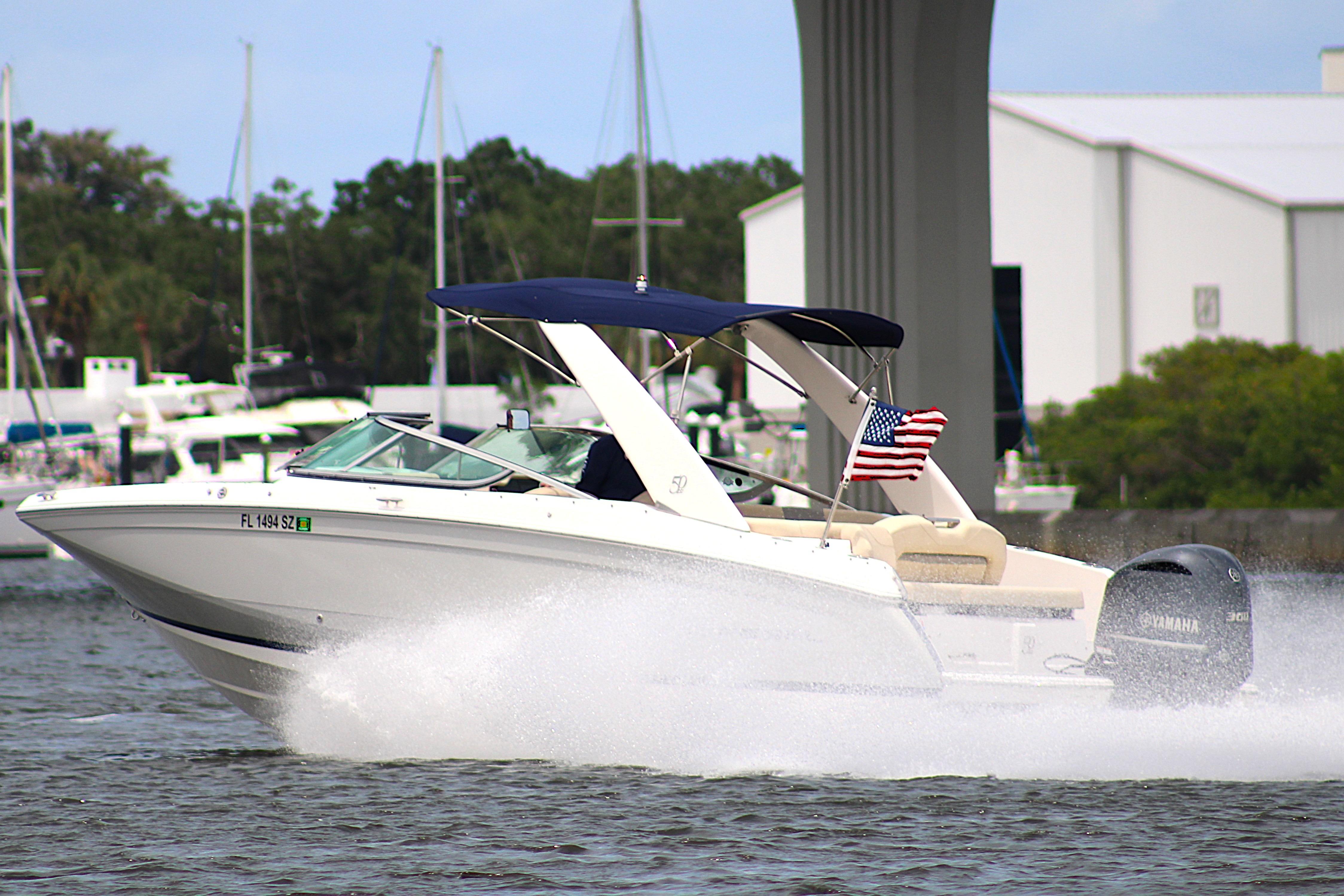 2021 Regal 26 OBX boat cruising on water with American flag.