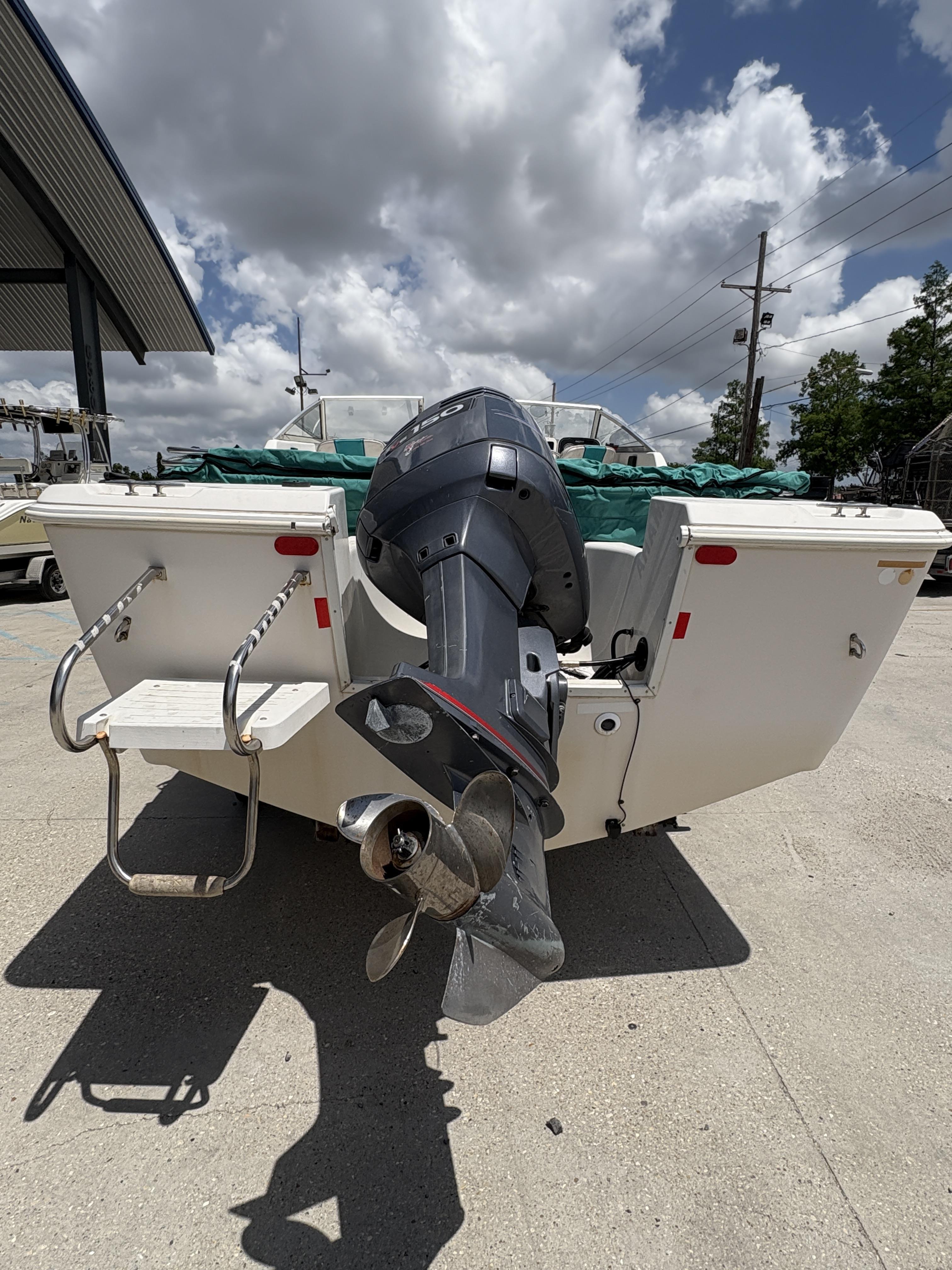 1996 Pro-Line 202 boat with outboard motor, docked under cloudy sky.