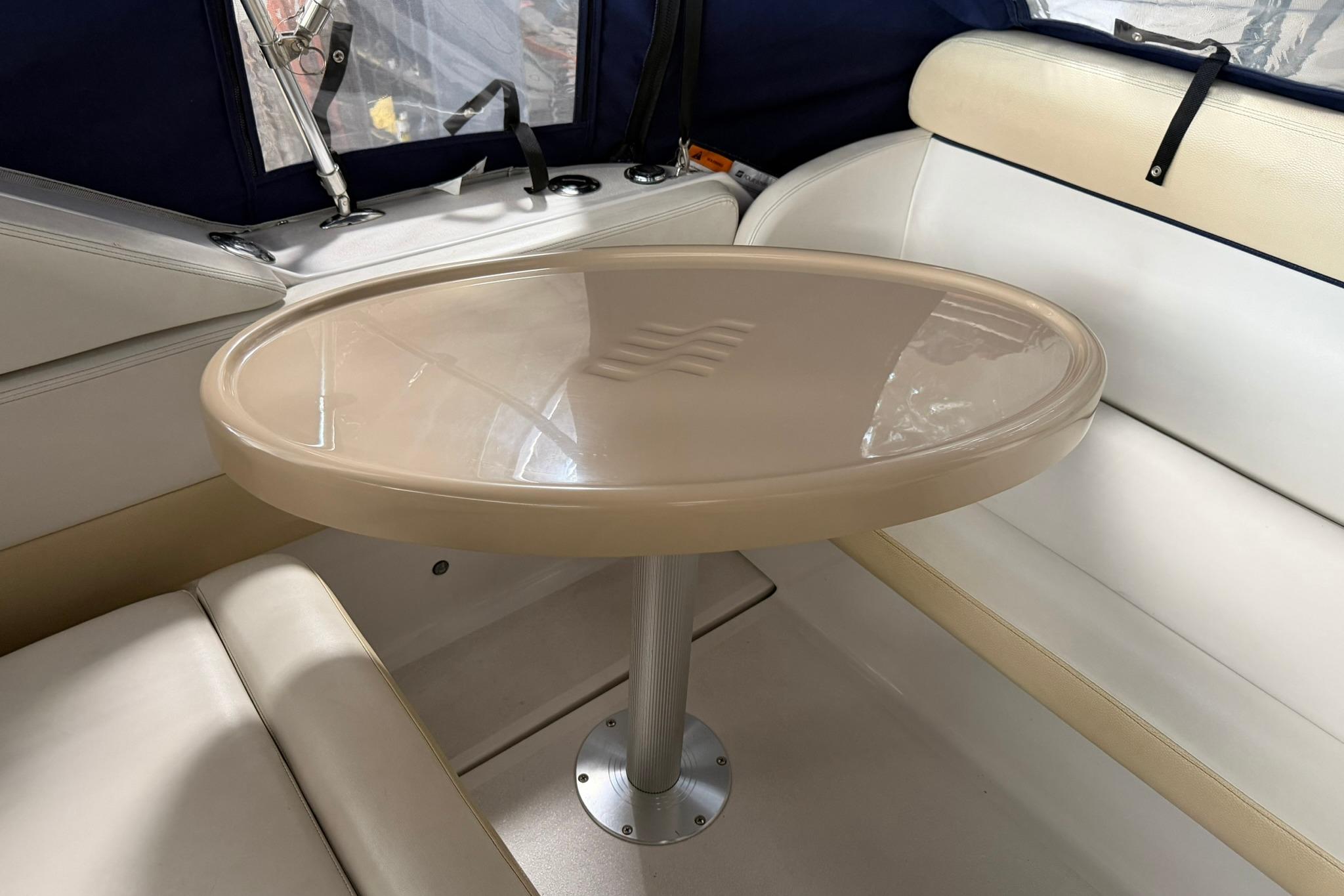 Interior of 2008 Four Winns V248 boat with oval table and cushioned seating.