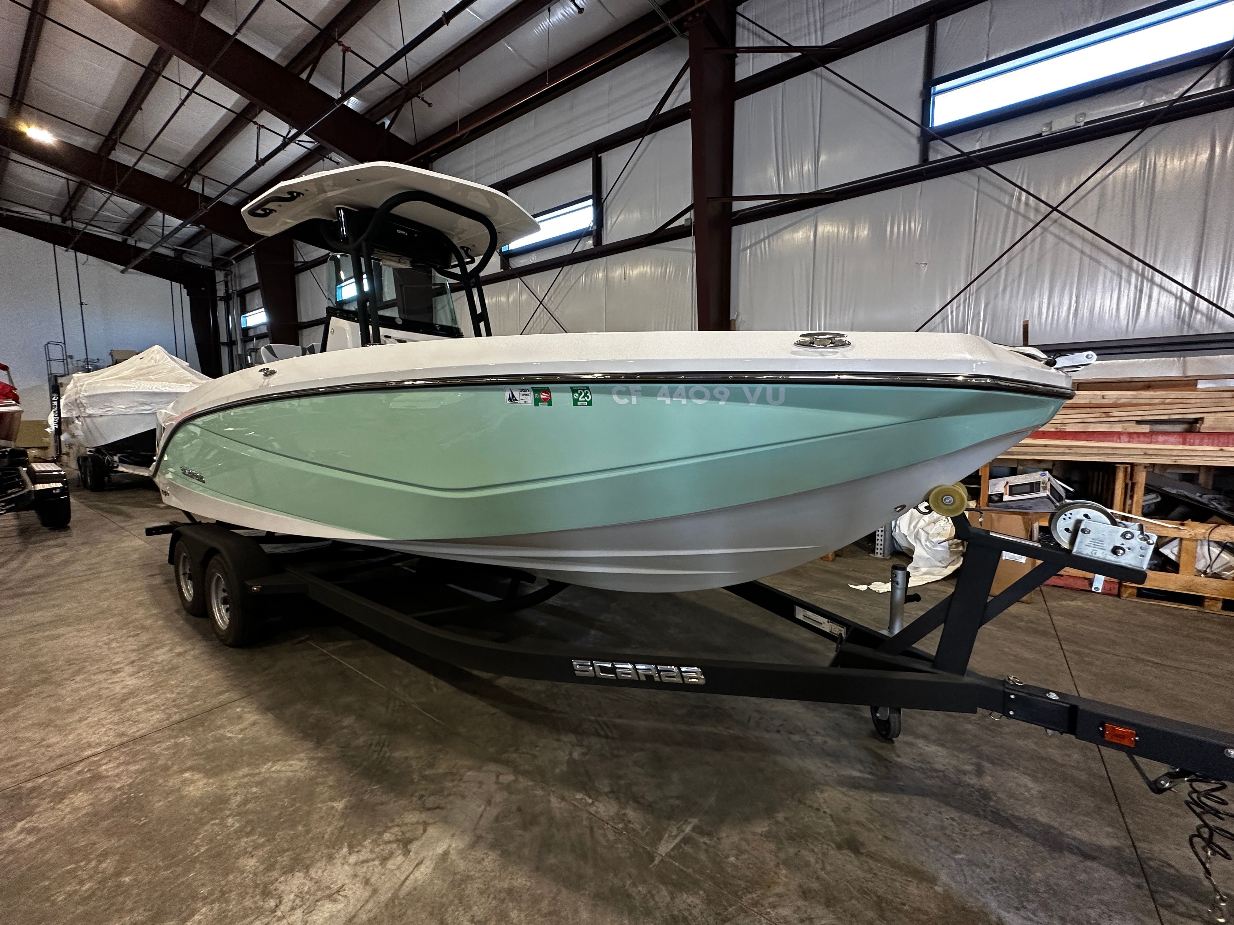 A 2021 Scarab 255 Open ID boat on a trailer inside a warehouse.