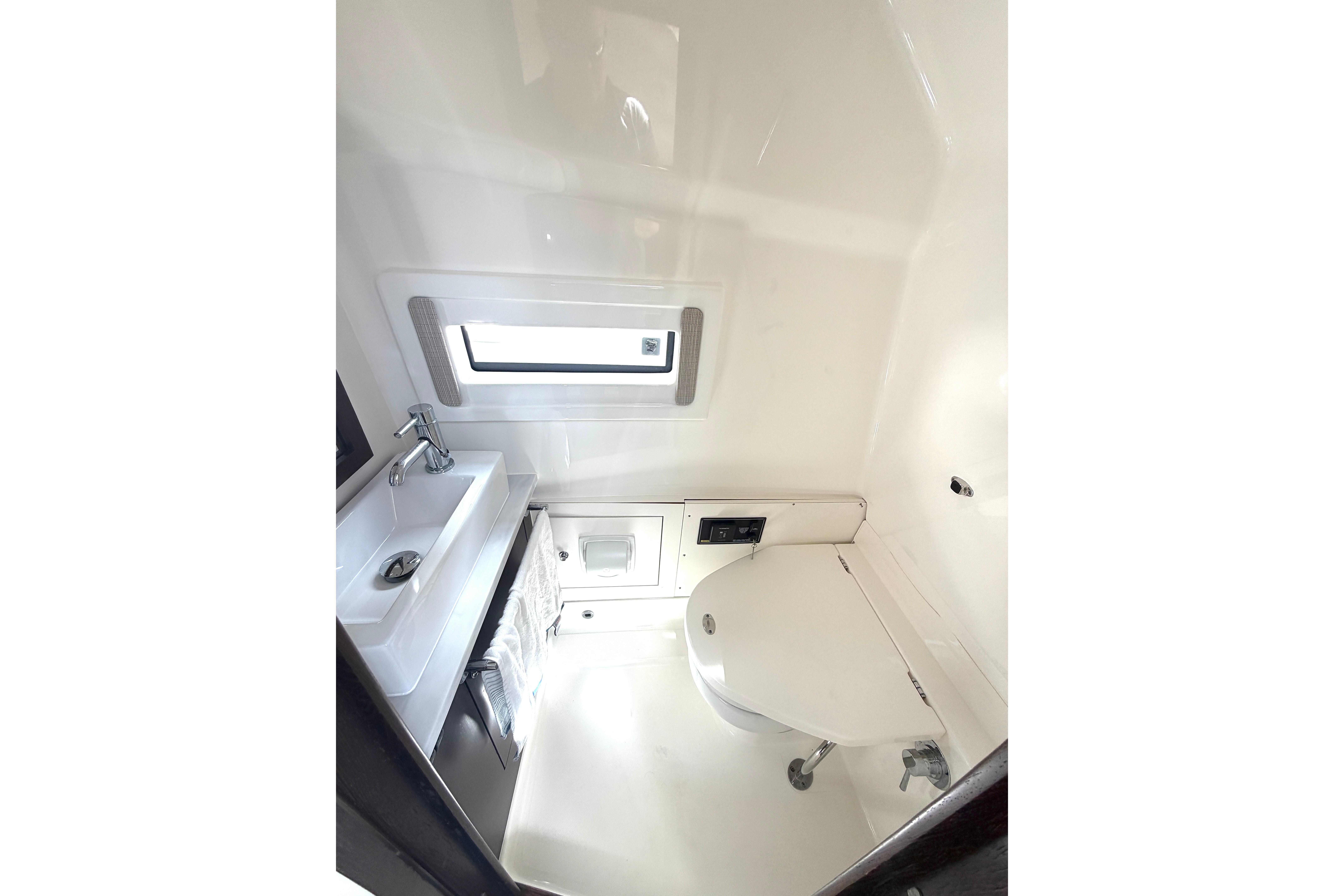 2021 Pursuit S 378 Sport boat bathroom with sink, toilet, and window.