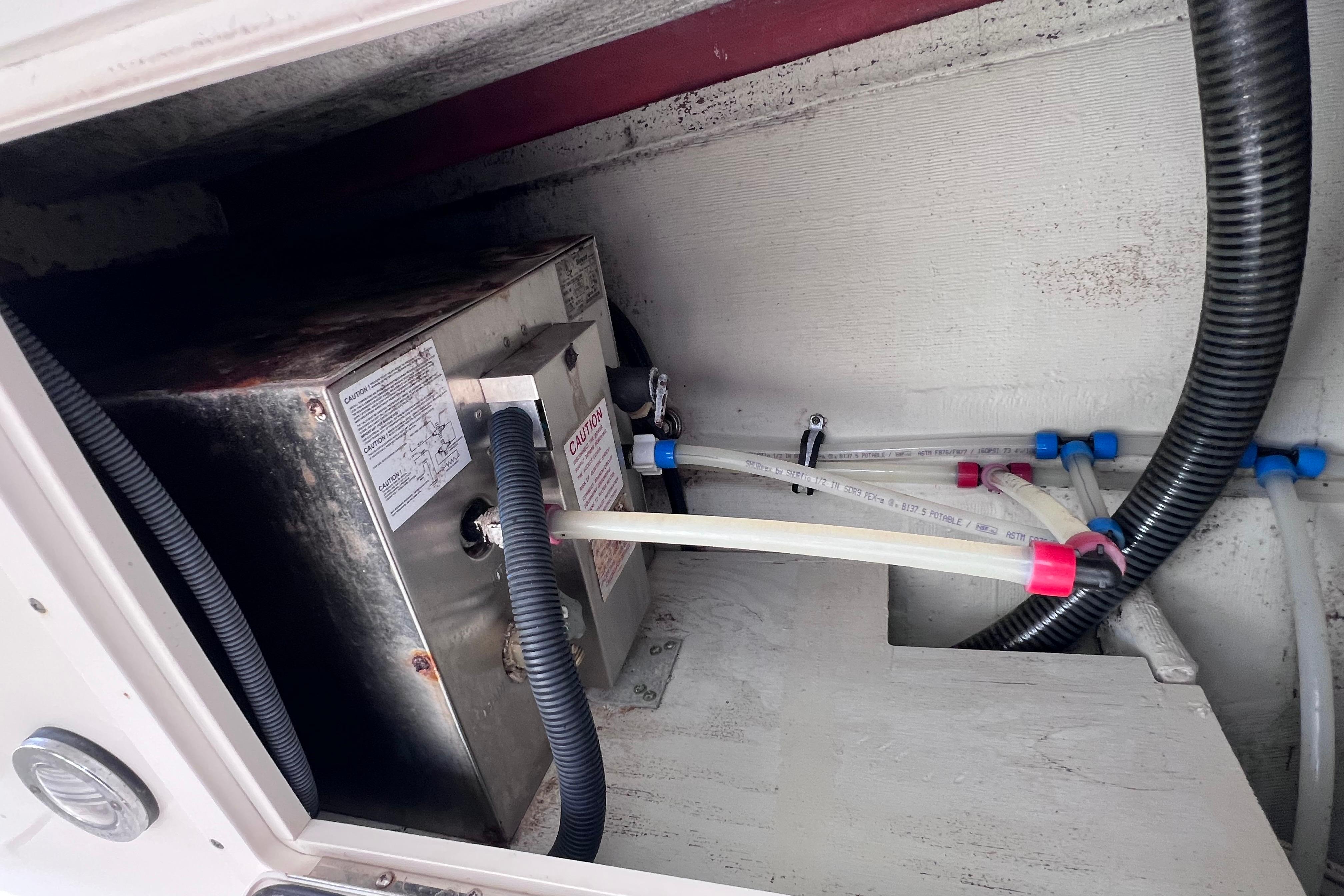2005 Pursuit 3070 Offshore boat interior showing plumbing and wiring components.