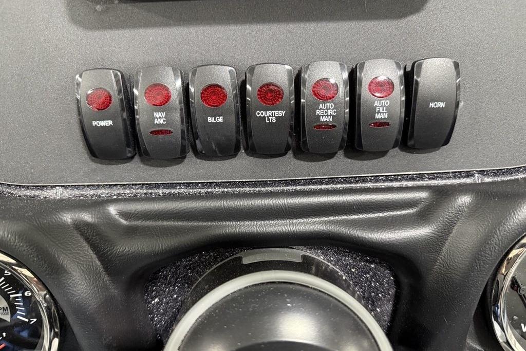 Dashboard switches of a 2025 Skeeter ZX150 boat, featuring various control functions.