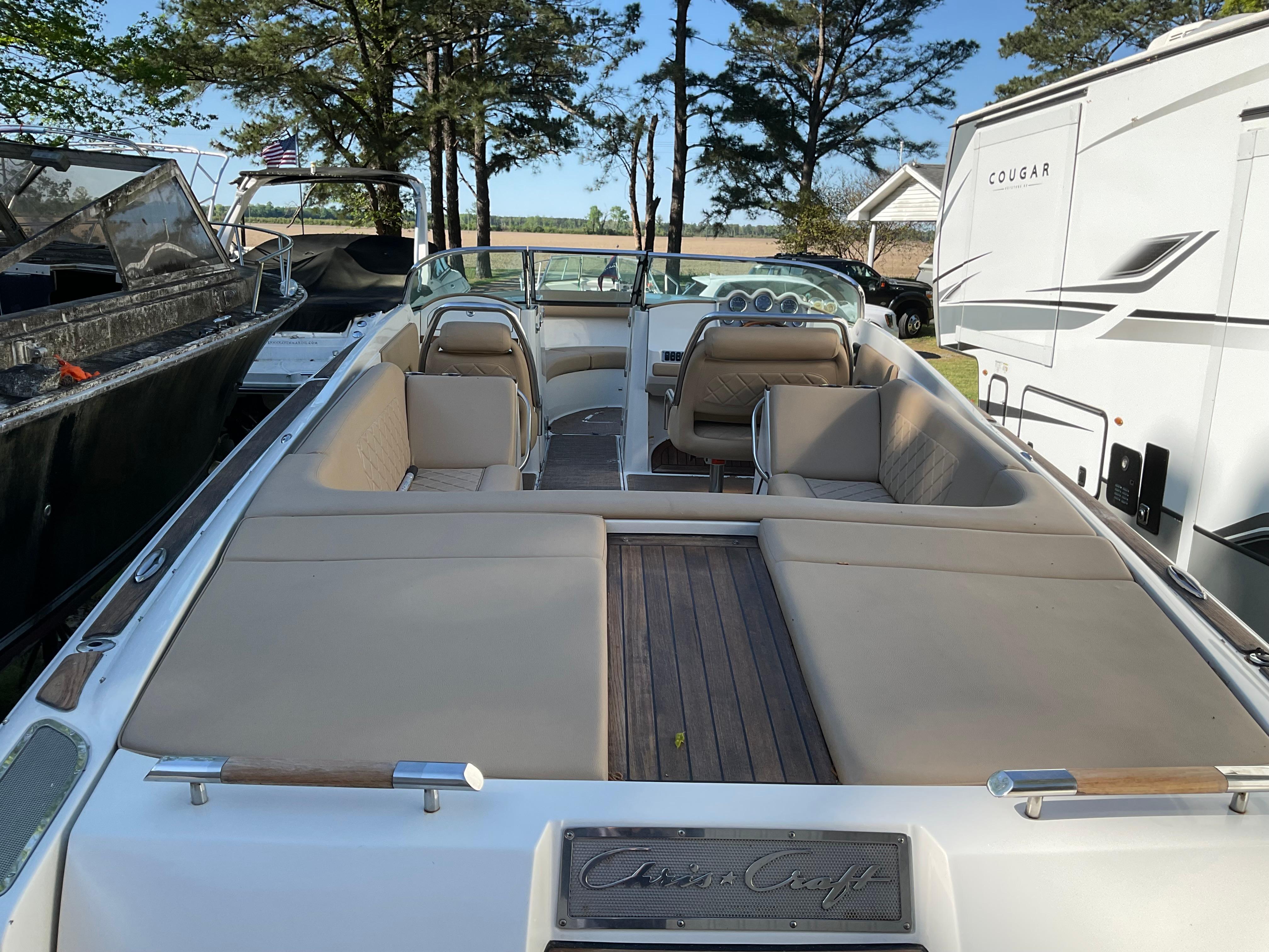 2014 Chris-Craft Launch 28 boat with beige seating, parked outdoors.