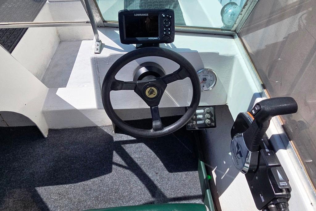 1971 Jupiter 15' Tri Hull boat cockpit with steering wheel and navigation equipment.