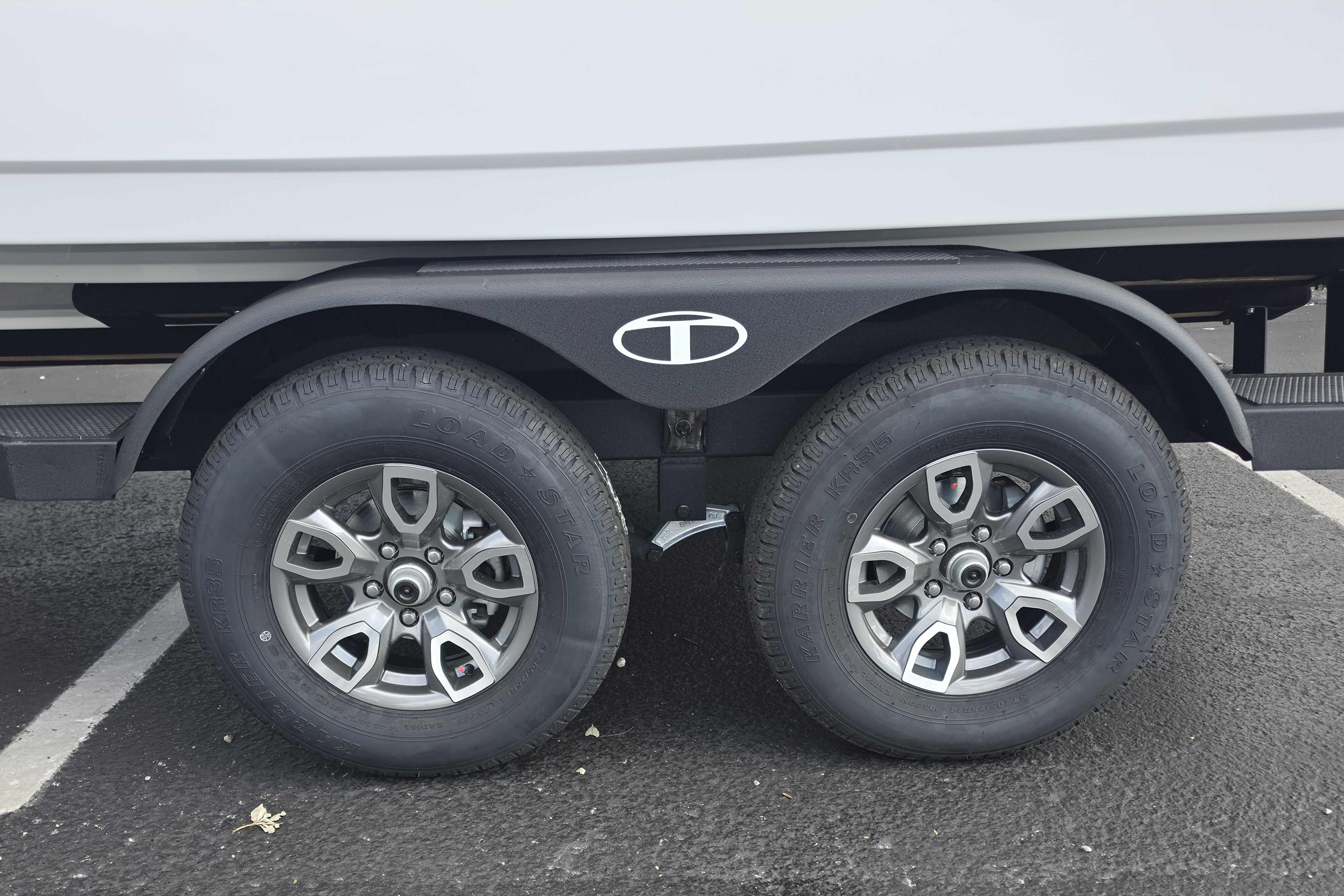 Trailer wheels of a 2026 Tahoe 2150 CC boat on asphalt.