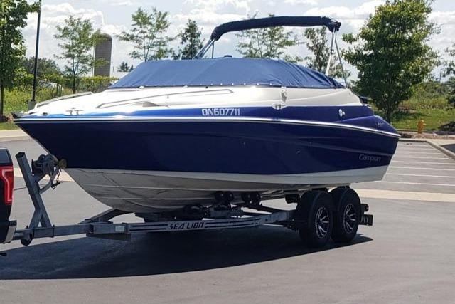 2001 Campion Allante 705 boat on trailer, blue cover, parked outdoors.