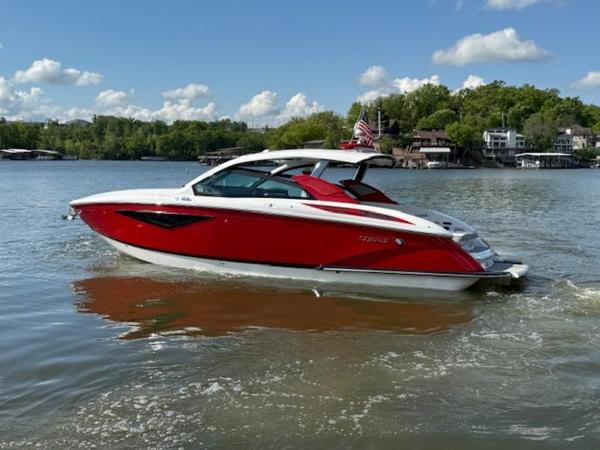2022 Cobalt A36BR boat in vibrant red on a serene lake.