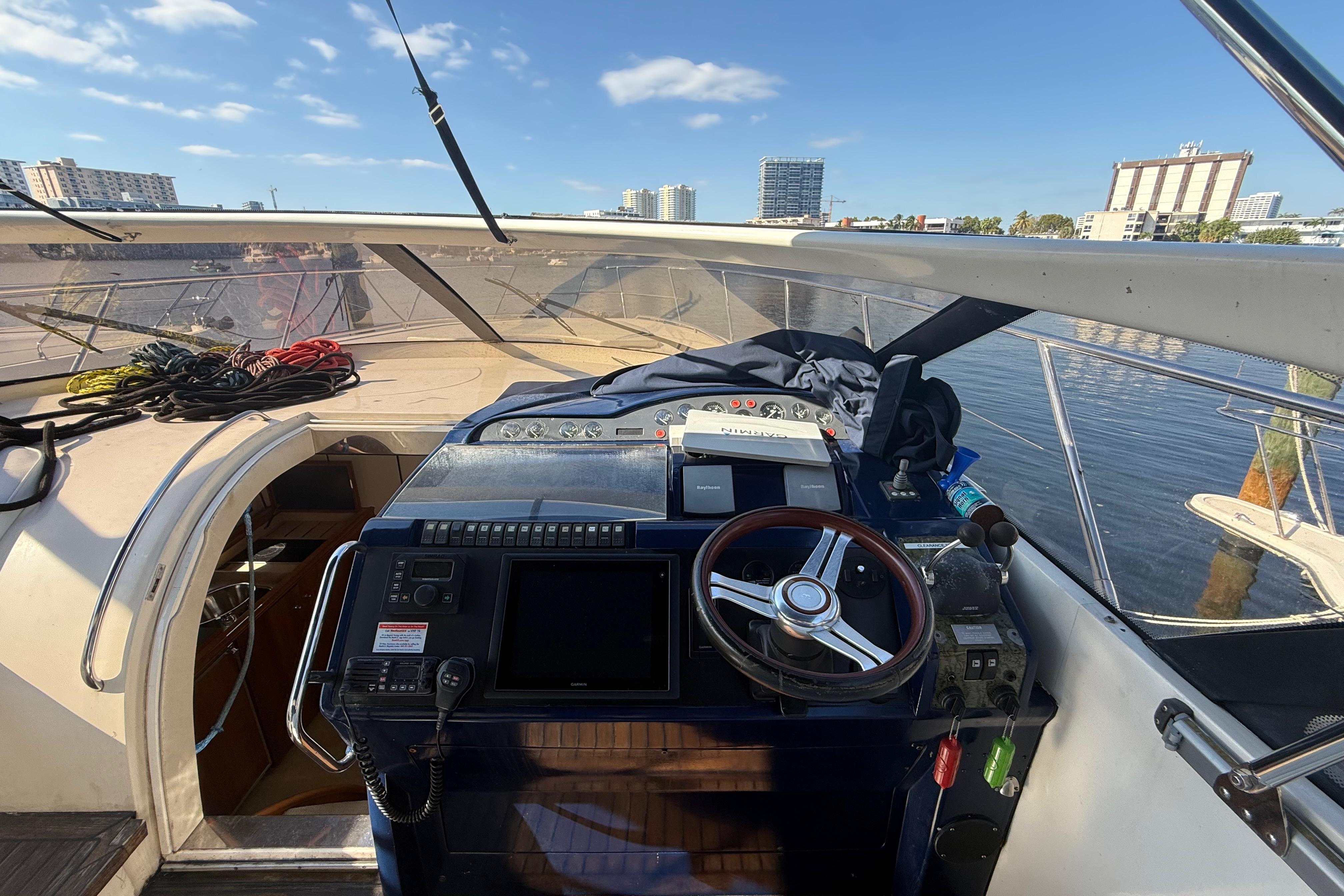 Helm of 2002 Viking Princess V50 yacht with cityscape background.