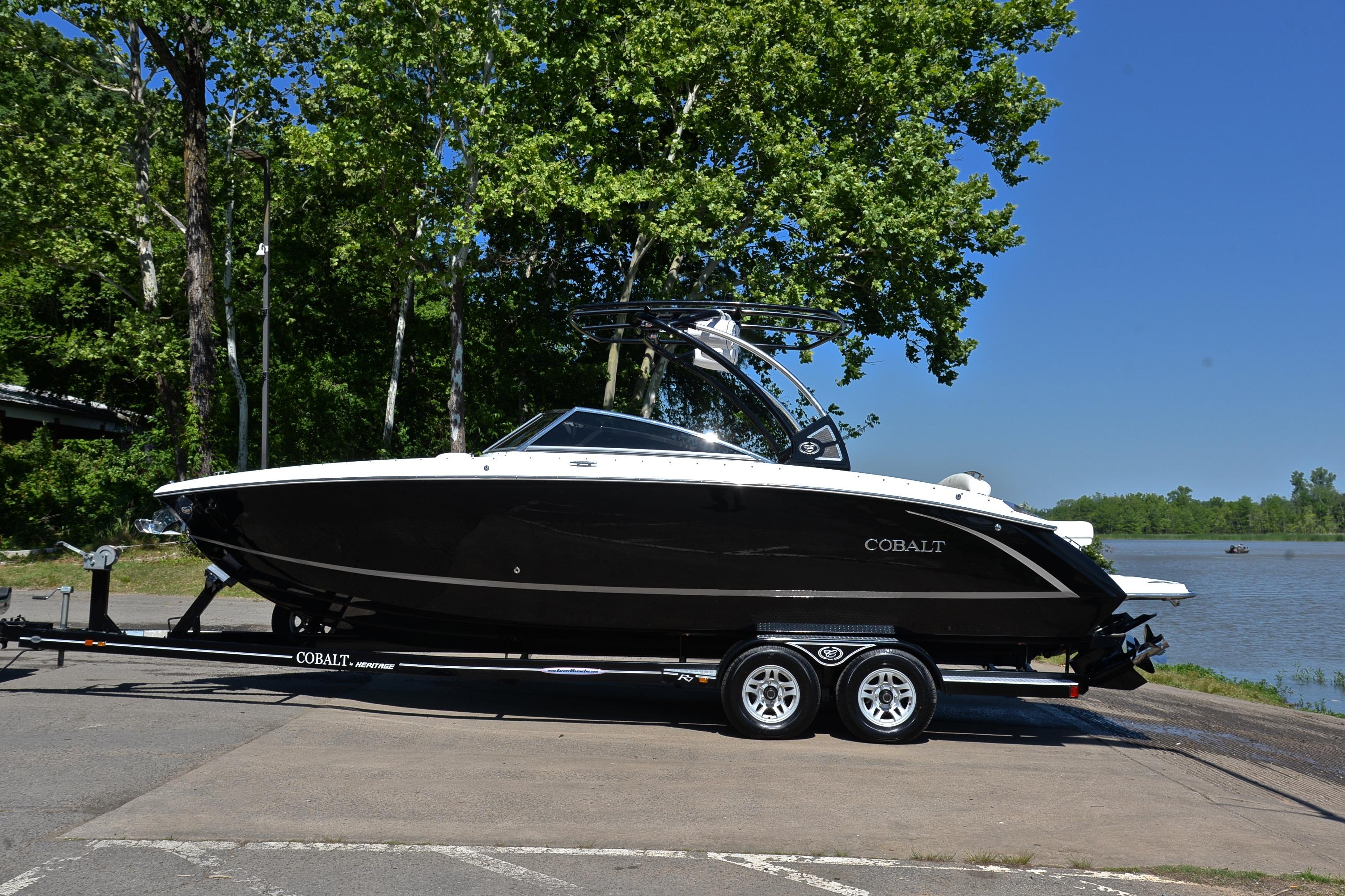 2018 Cobalt R7 boat on trailer by a lake, surrounded by trees.
