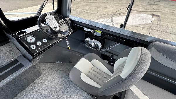 2024 Spartan 200 Astoria boat interior with steering wheel and control panel.
