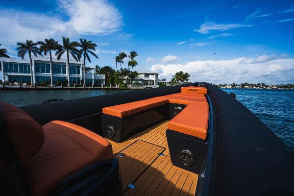 2024 Onda Magna boat with orange seating on a sunny waterfront.