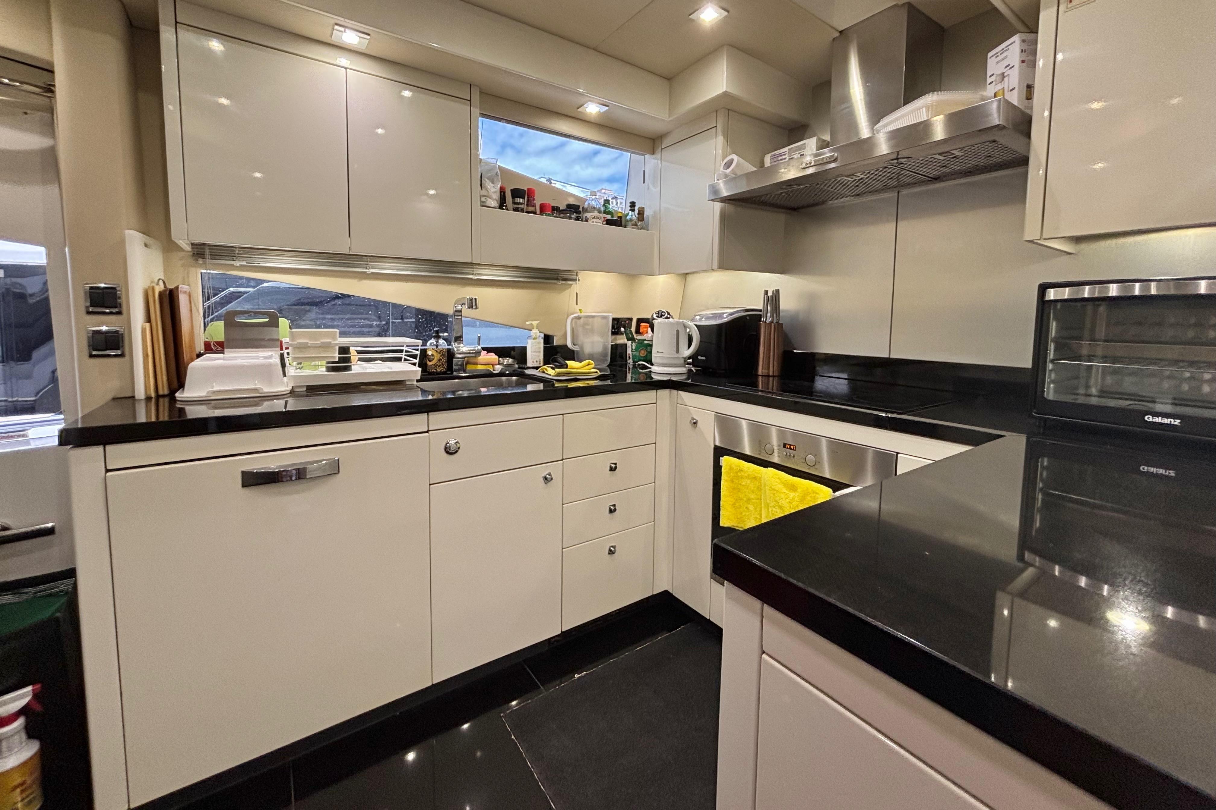 Modern kitchen interior on a 2011 Sunseeker 88 Yacht, featuring sleek cabinetry and appliances.