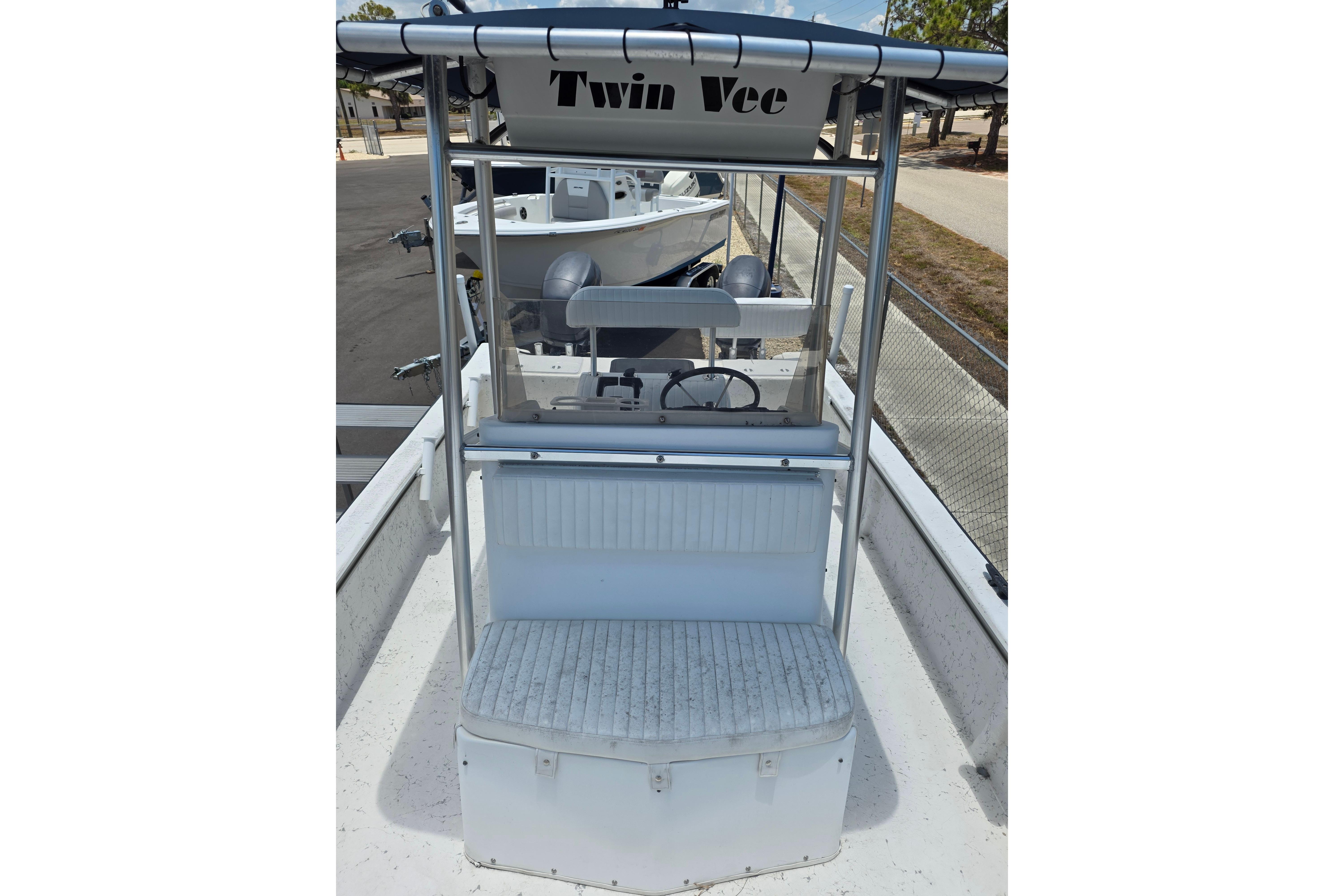 1999 Twin Vee Awesome 22 boat with T-top and seating, docked outdoors.