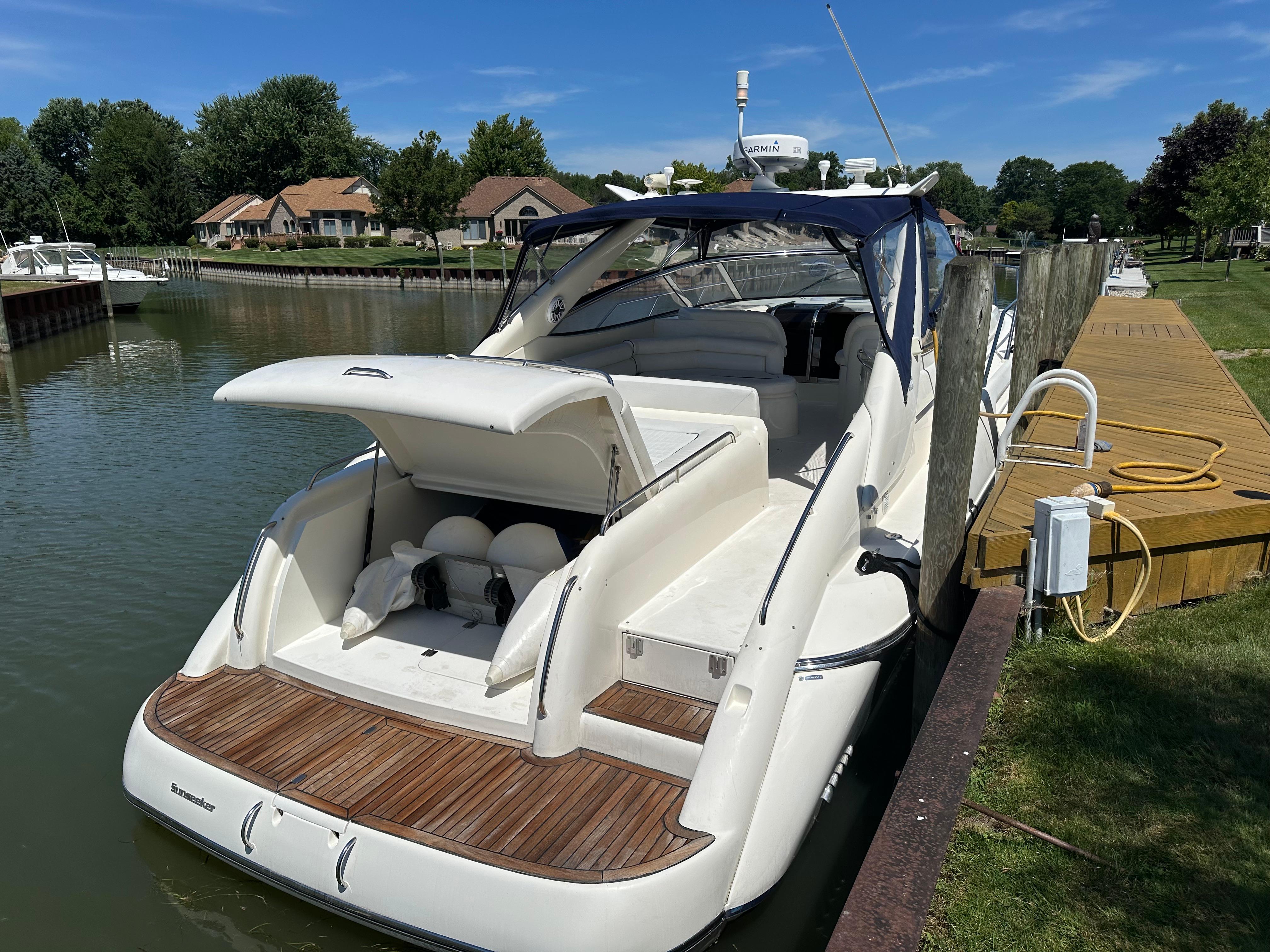 1997 Sunseeker Camargue 47 yacht docked by a wooden pier on a sunny day.