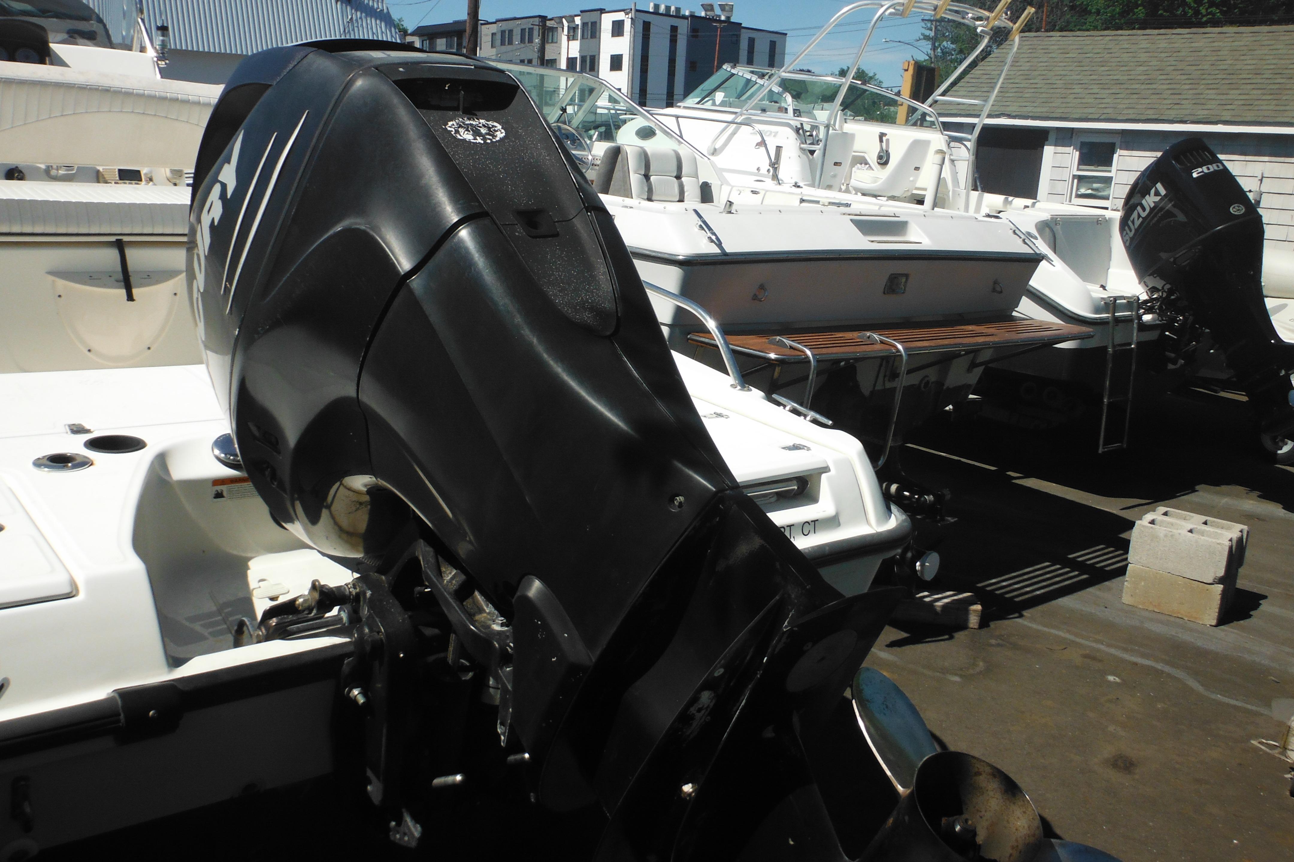 2009 Boston Whaler 200 Dauntless boat with powerful outboard motor in a marina setting.