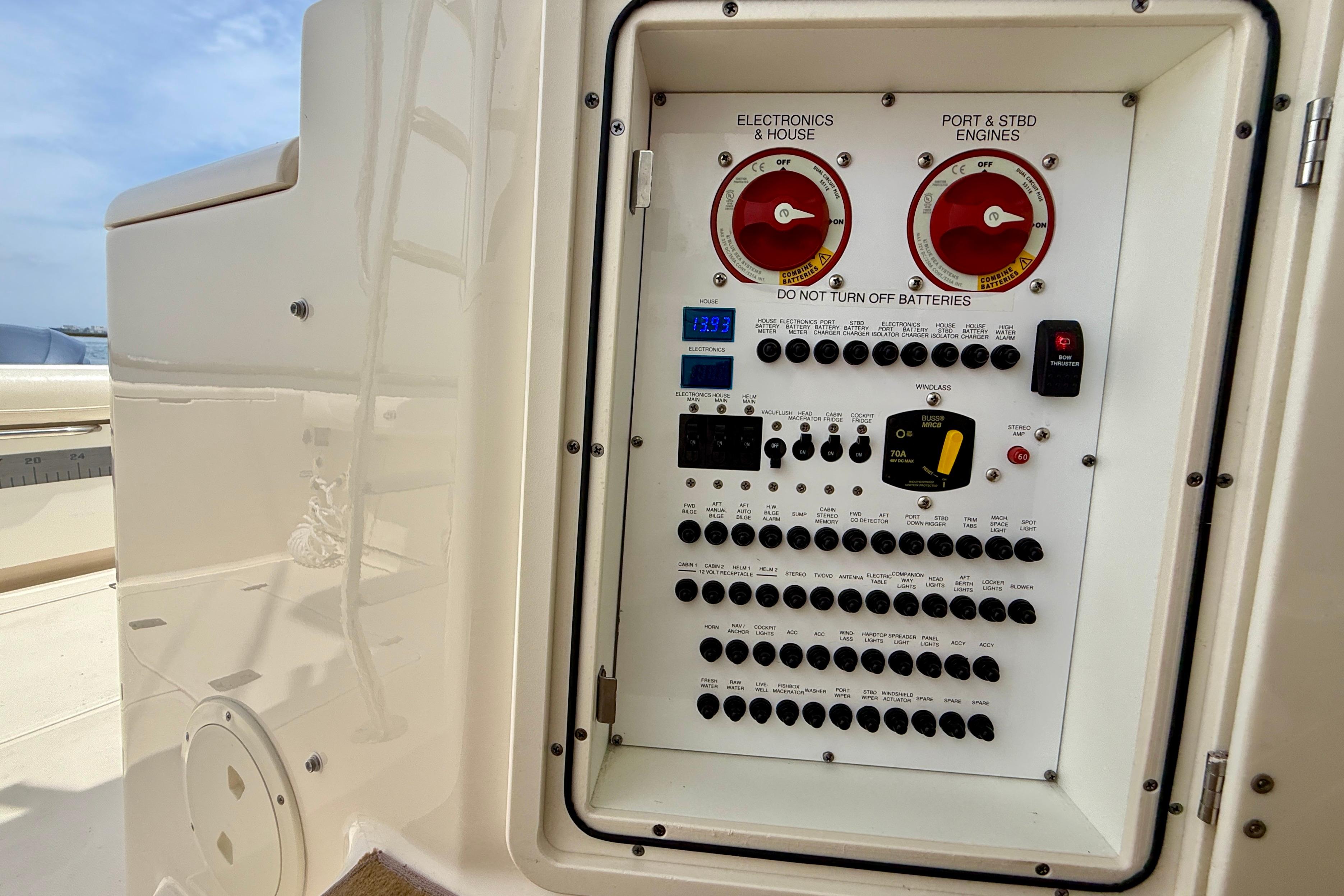 Control panel of a 2012 Pursuit OS 345 Offshore boat, featuring switches and battery controls.