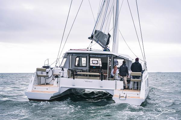 2025 Nautitech 40 Open catamaran sailing on open sea, rear view.