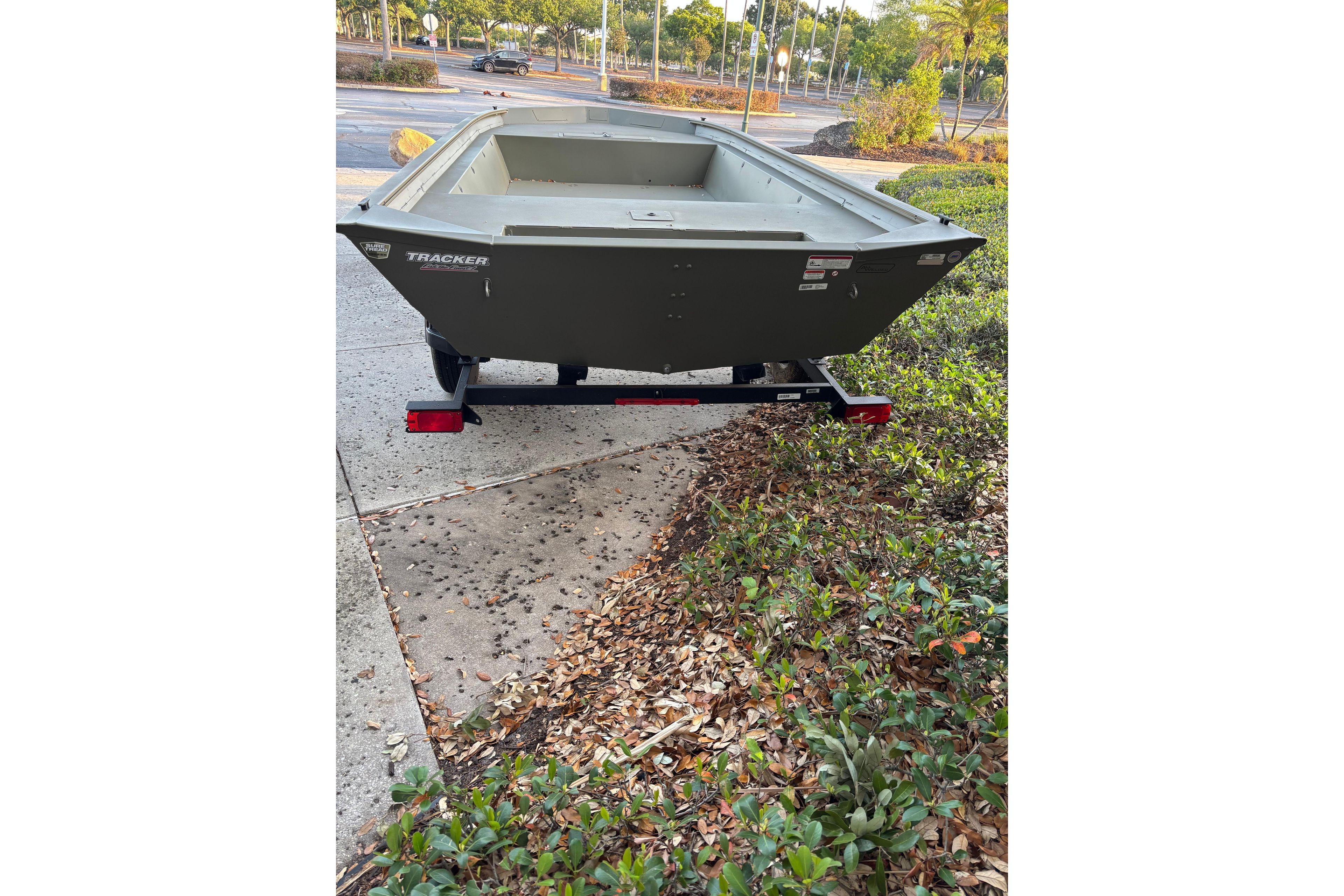 2026 Tracker Grizzly 1860 Utility boat on trailer, parked outdoors.