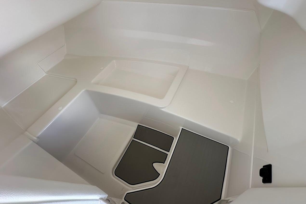 Interior view of 2026 Sea Ray SDX 230 Surf boat cabin, featuring sleek white design.