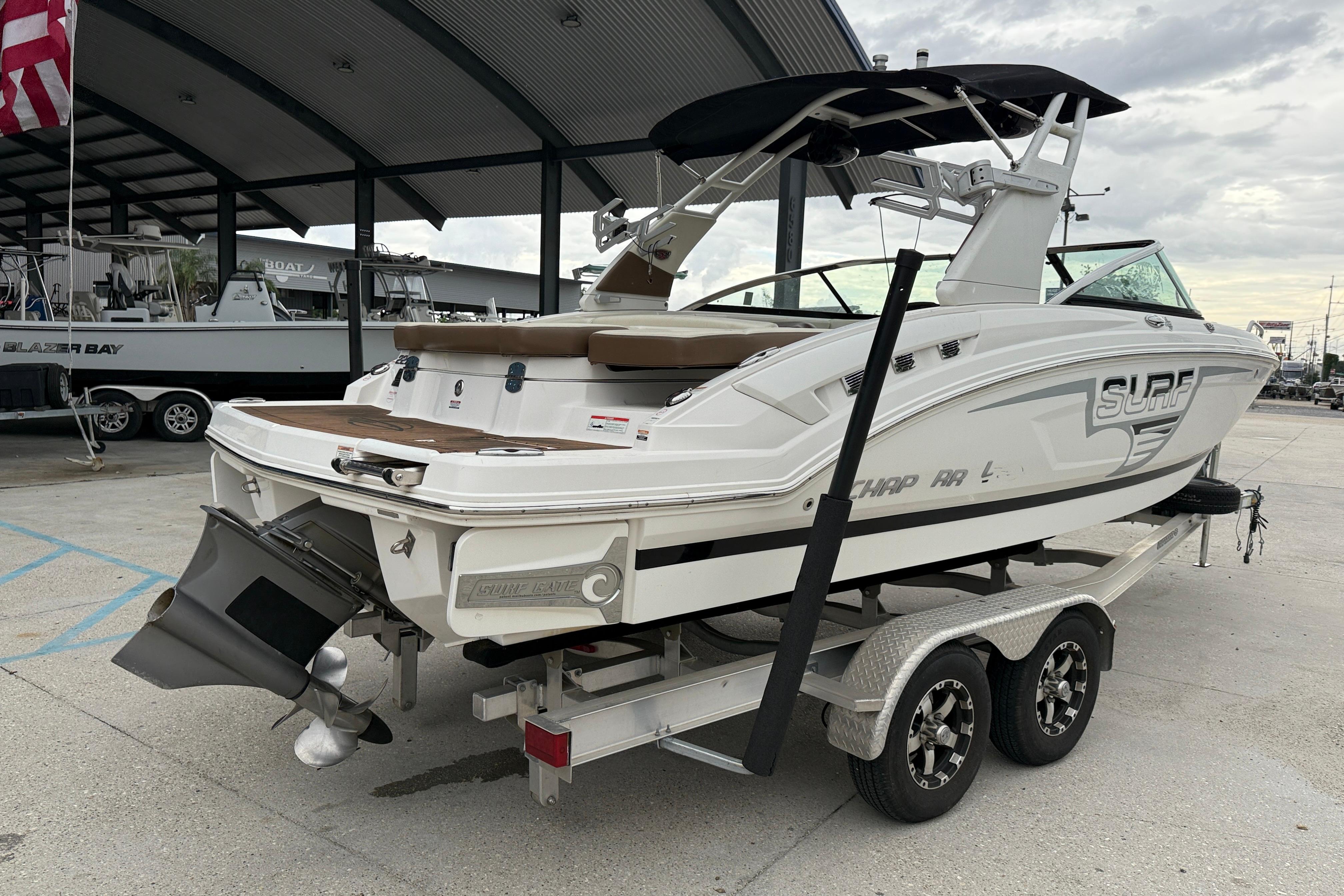 2018 Chaparral 227 SSX Surf boat on trailer at marina.