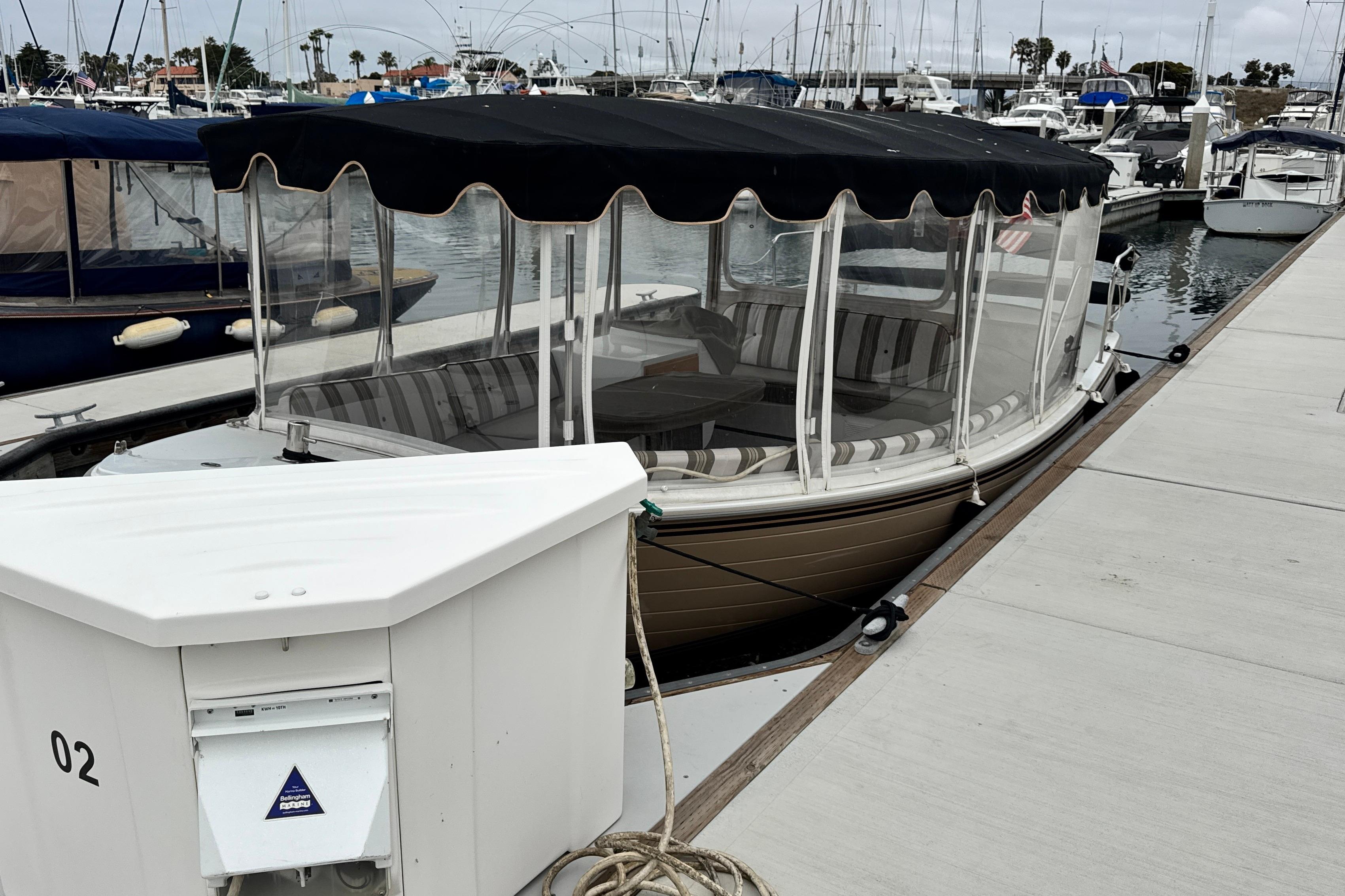 2023 Duffy Bay Cruiser docked at marina with striped seating and canopy.