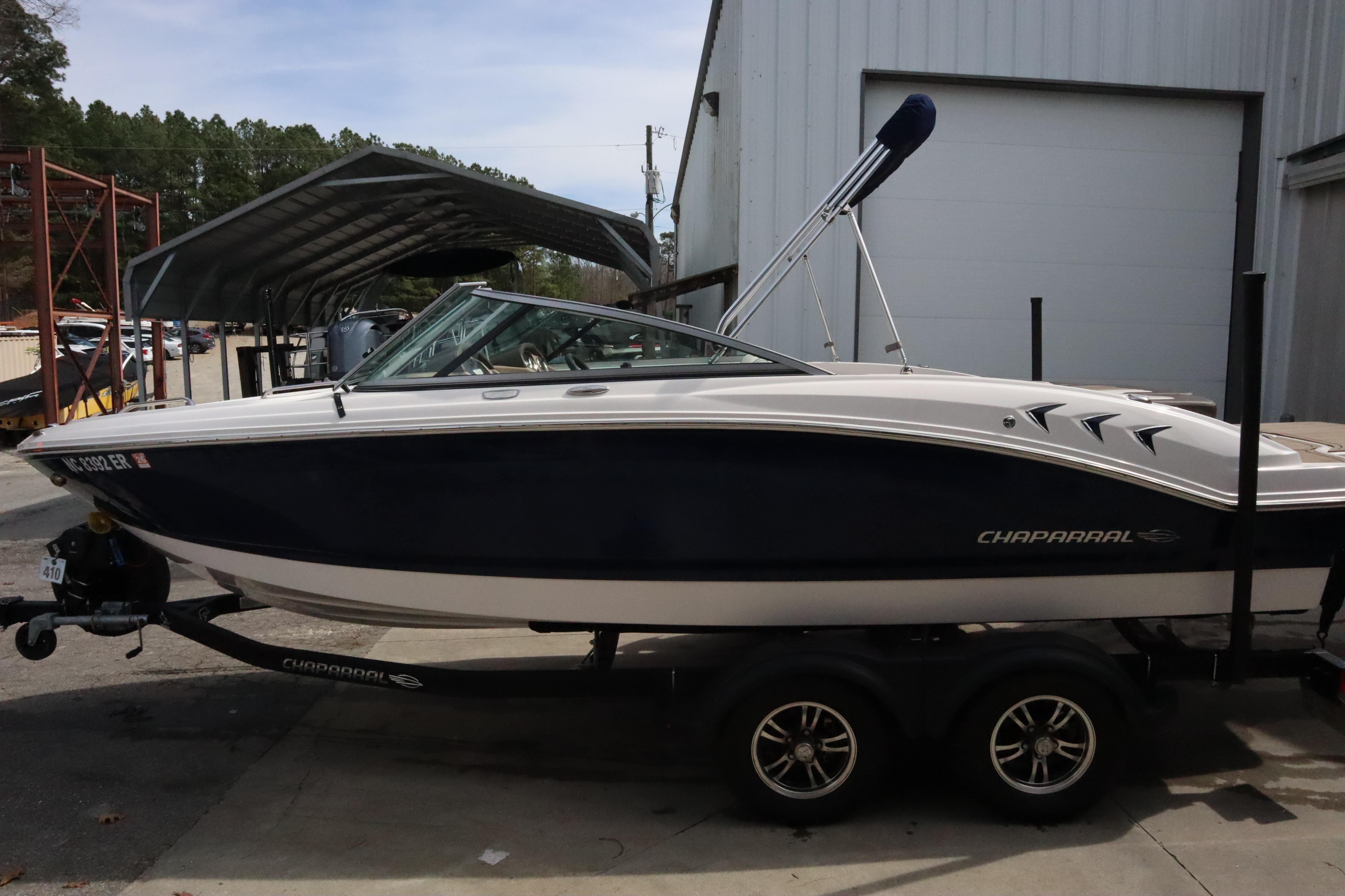 2021 Chaparral 21 SSi boat on trailer, parked near a building.