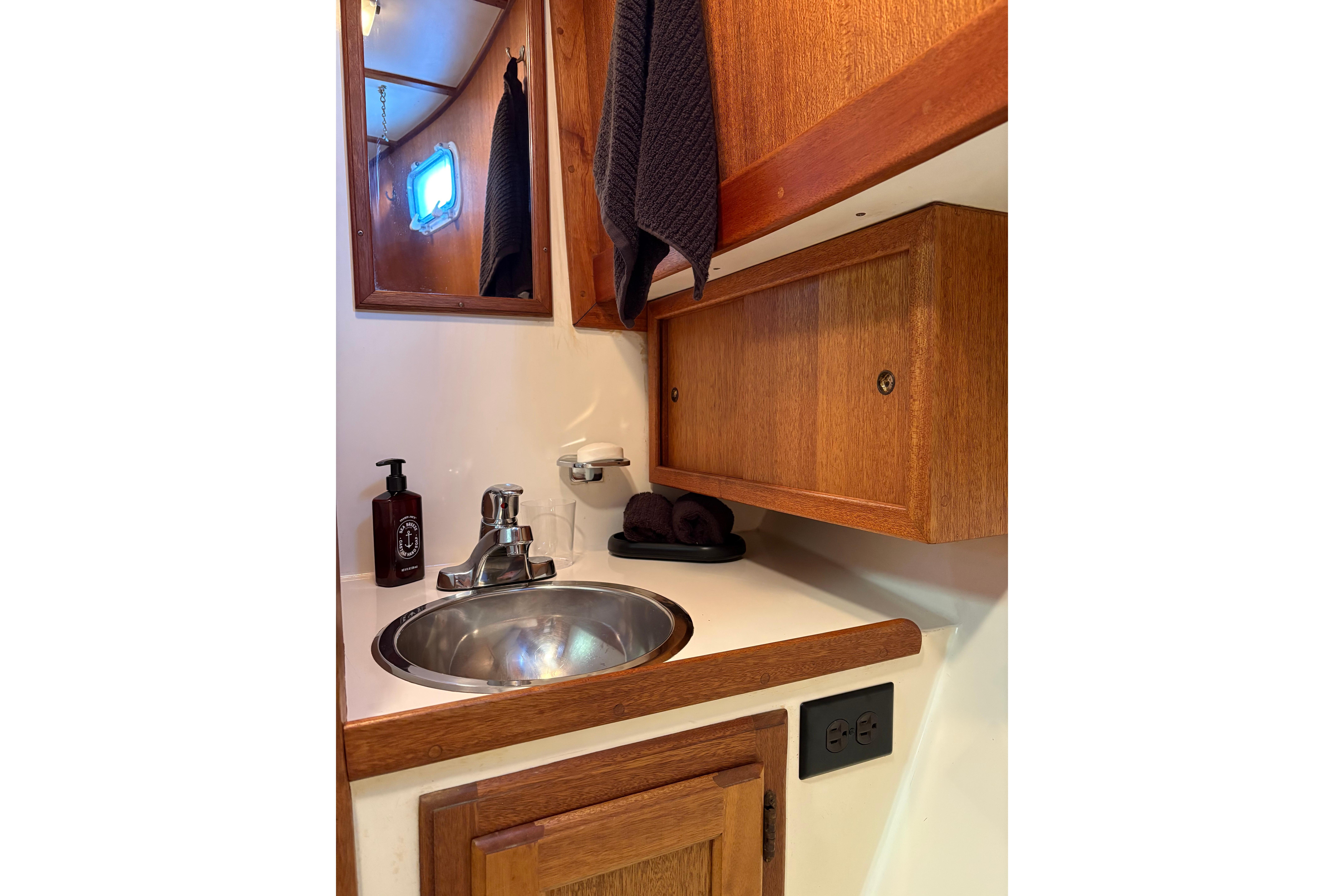 1978 Californian 42 LRC yacht bathroom with wooden cabinets and stainless steel sink.