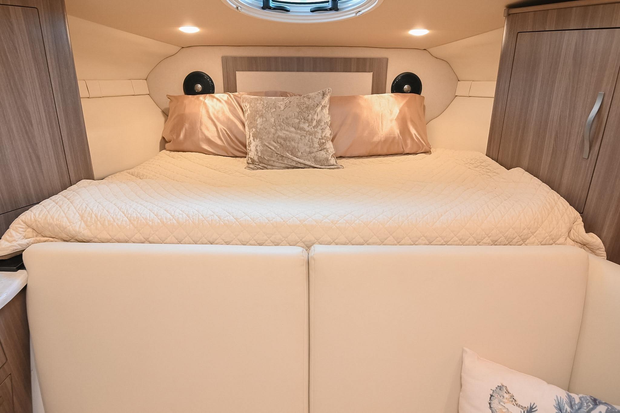 Luxurious cabin interior of 2021 Regal 33 Express yacht with cozy bedding.