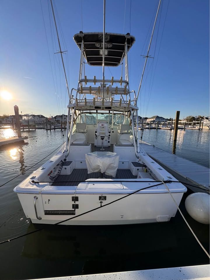 A 2005 Luhrs 32 Open boat is docked on the water. It features a spacious deck and flybridge.