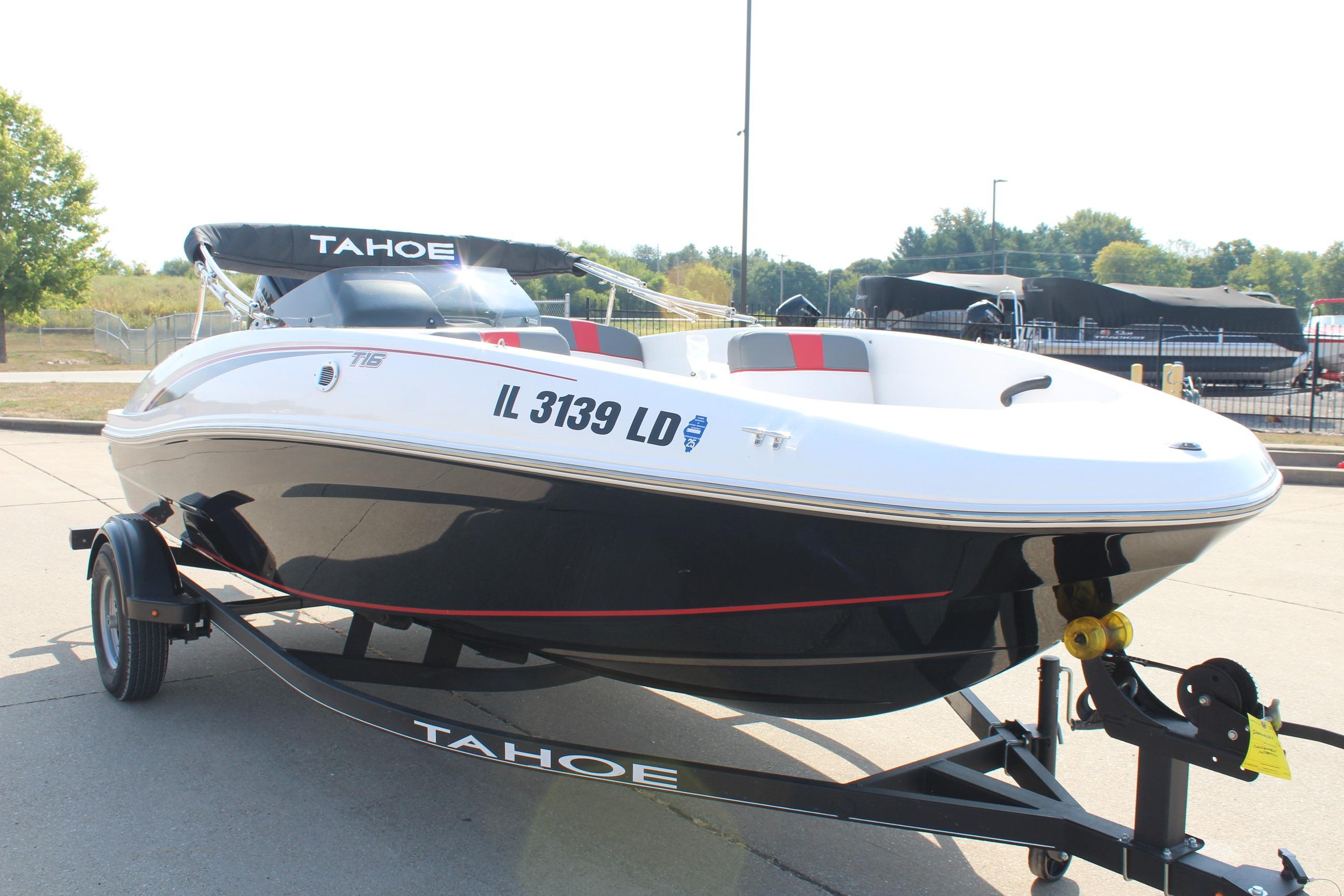 2023 Tahoe T16 boat on trailer, black and white design, parked outdoors.