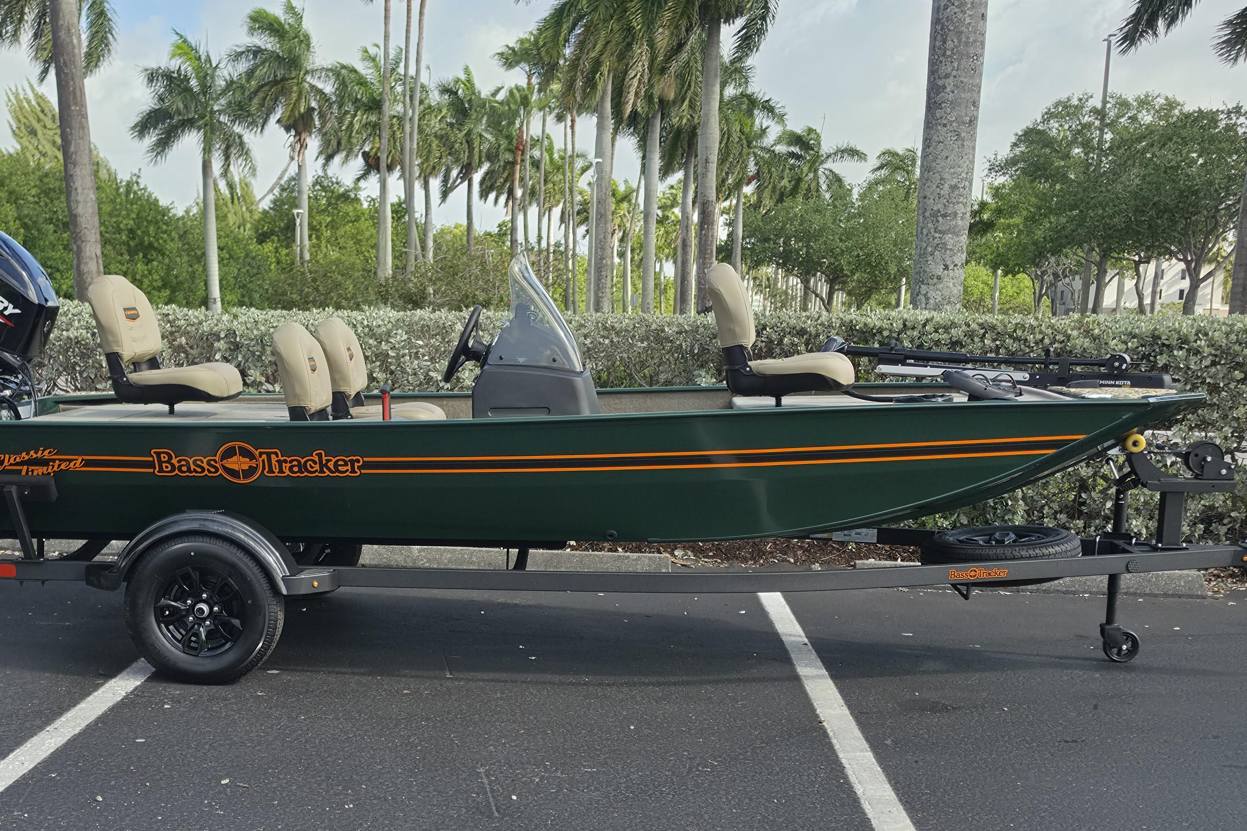 2026 Tracker Bass Tracker Classic Limited boat on trailer, parked with palm trees in background.