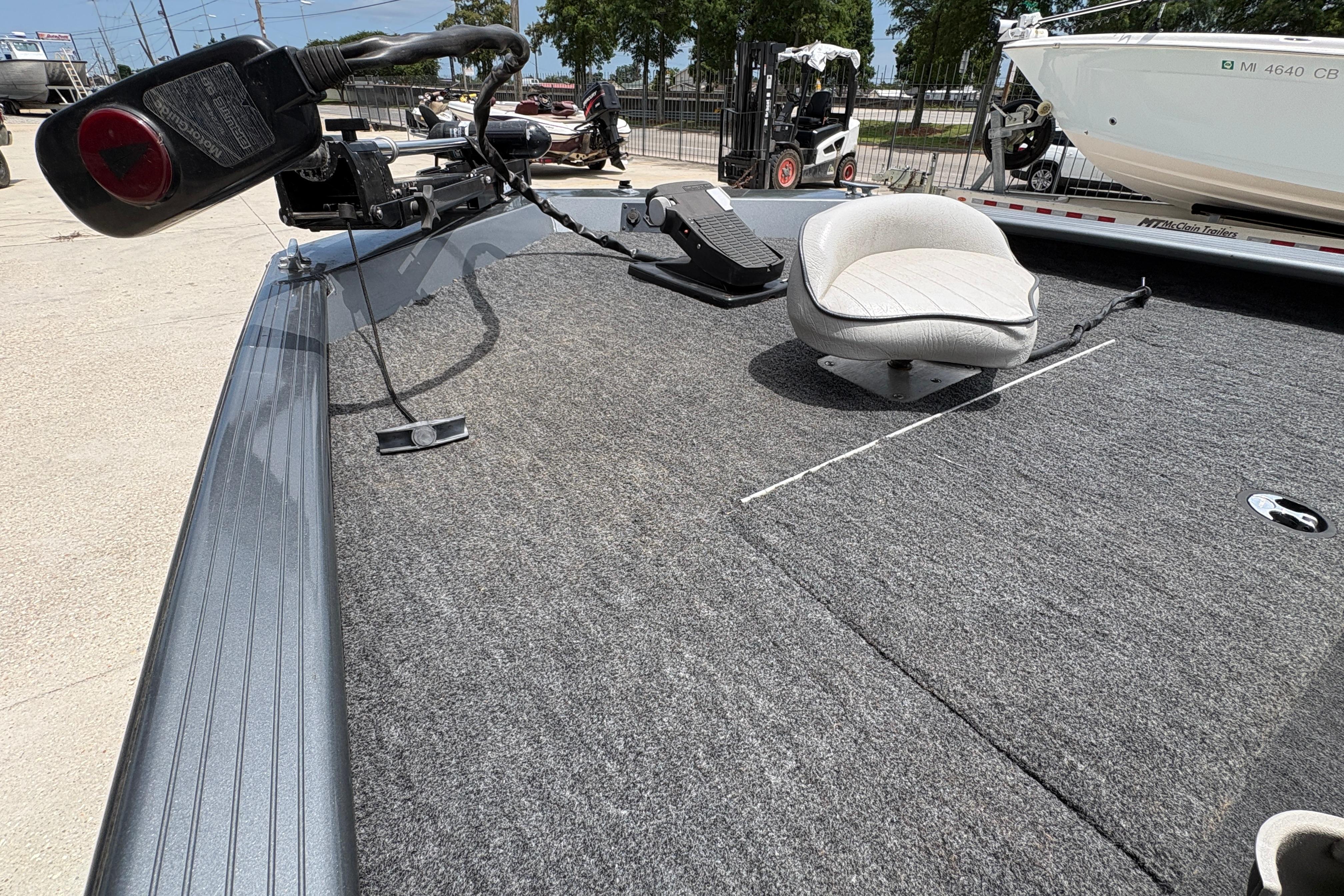 2000 Xpress X18 boat deck with seating and trolling motor in a marina setting.