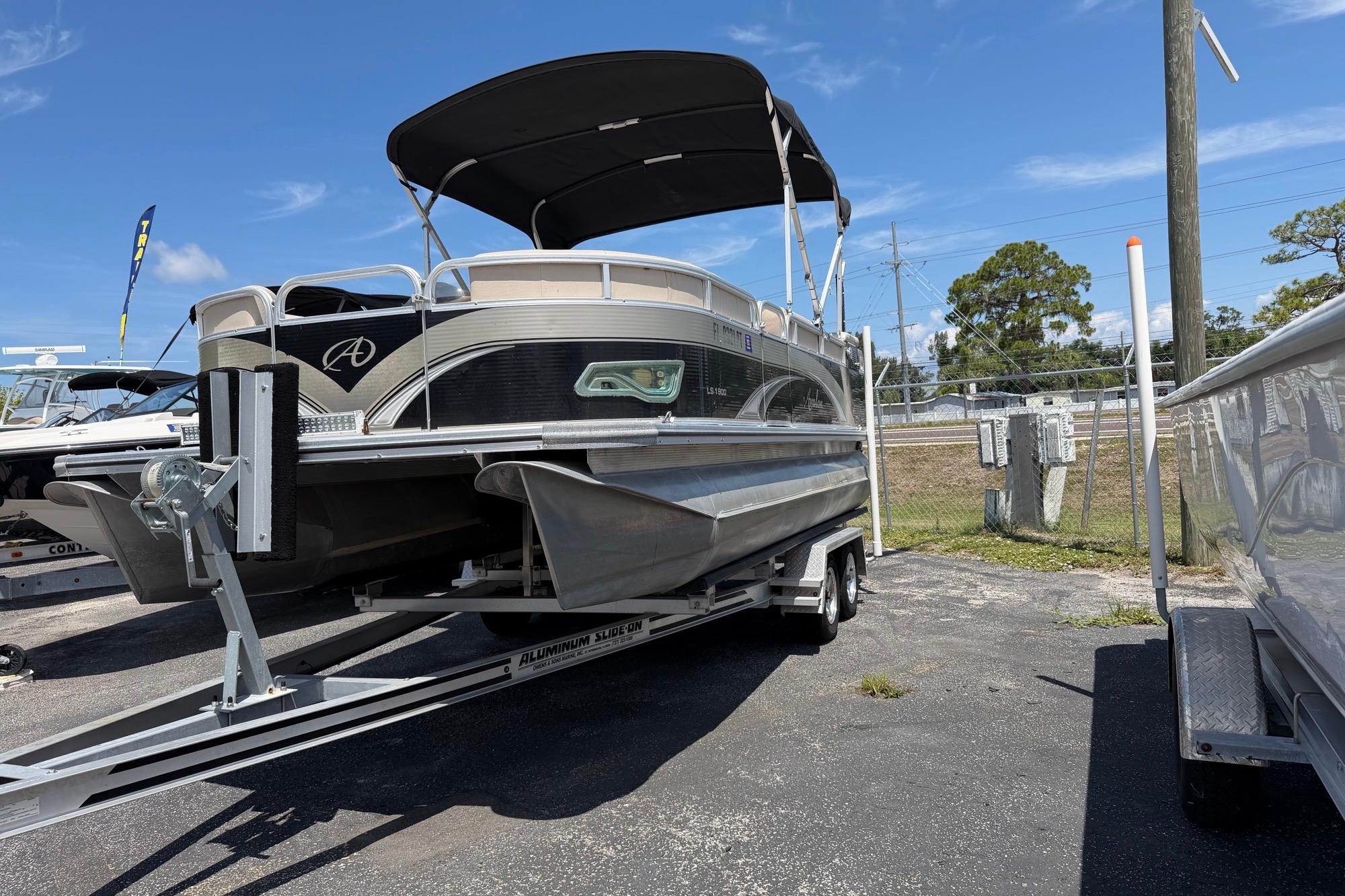 2014 Avalon 1900 pontoon boat on trailer under clear blue sky.