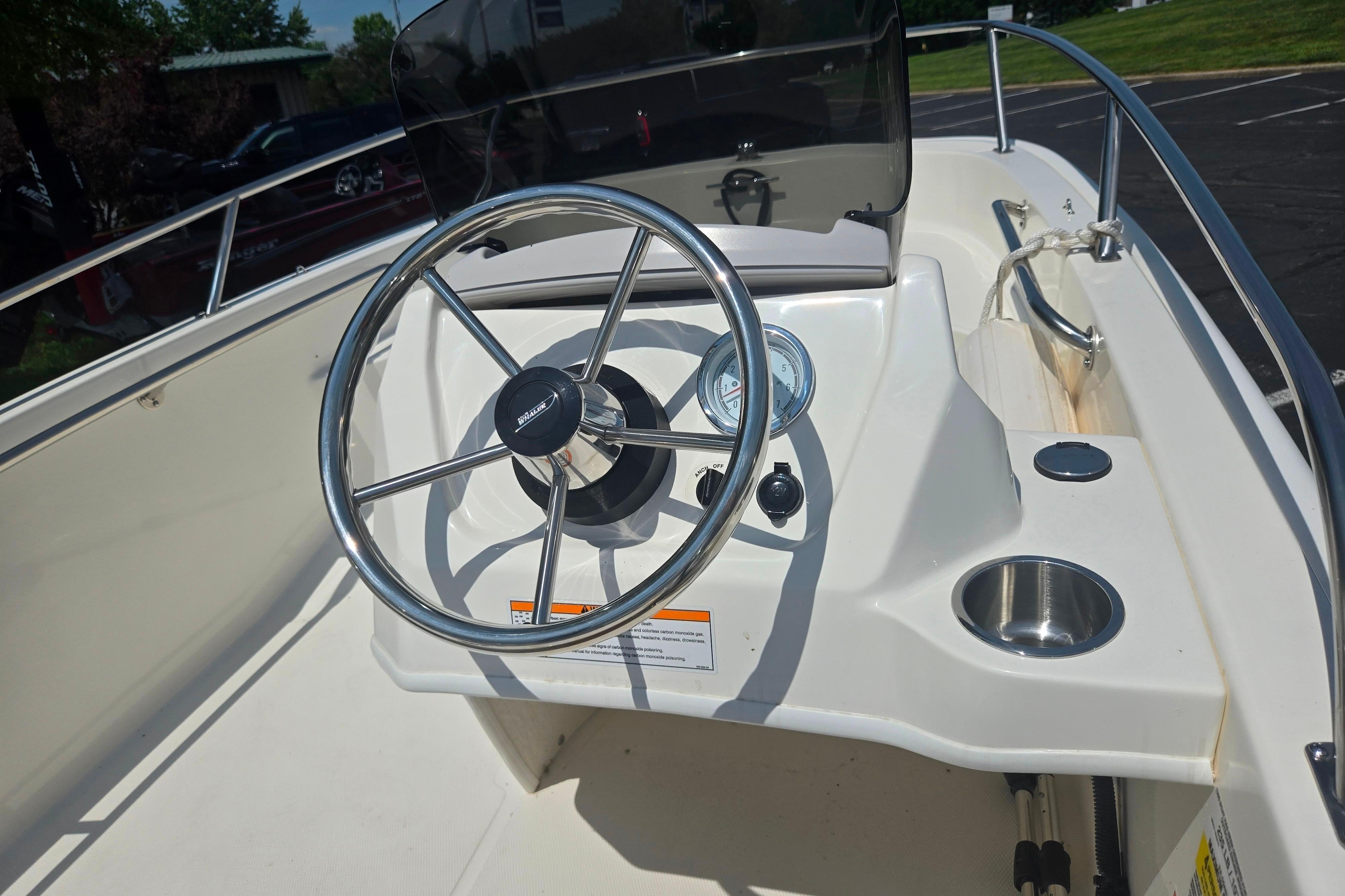 Steering console of 2025 Boston Whaler 130 Super Sport boat with chrome details.