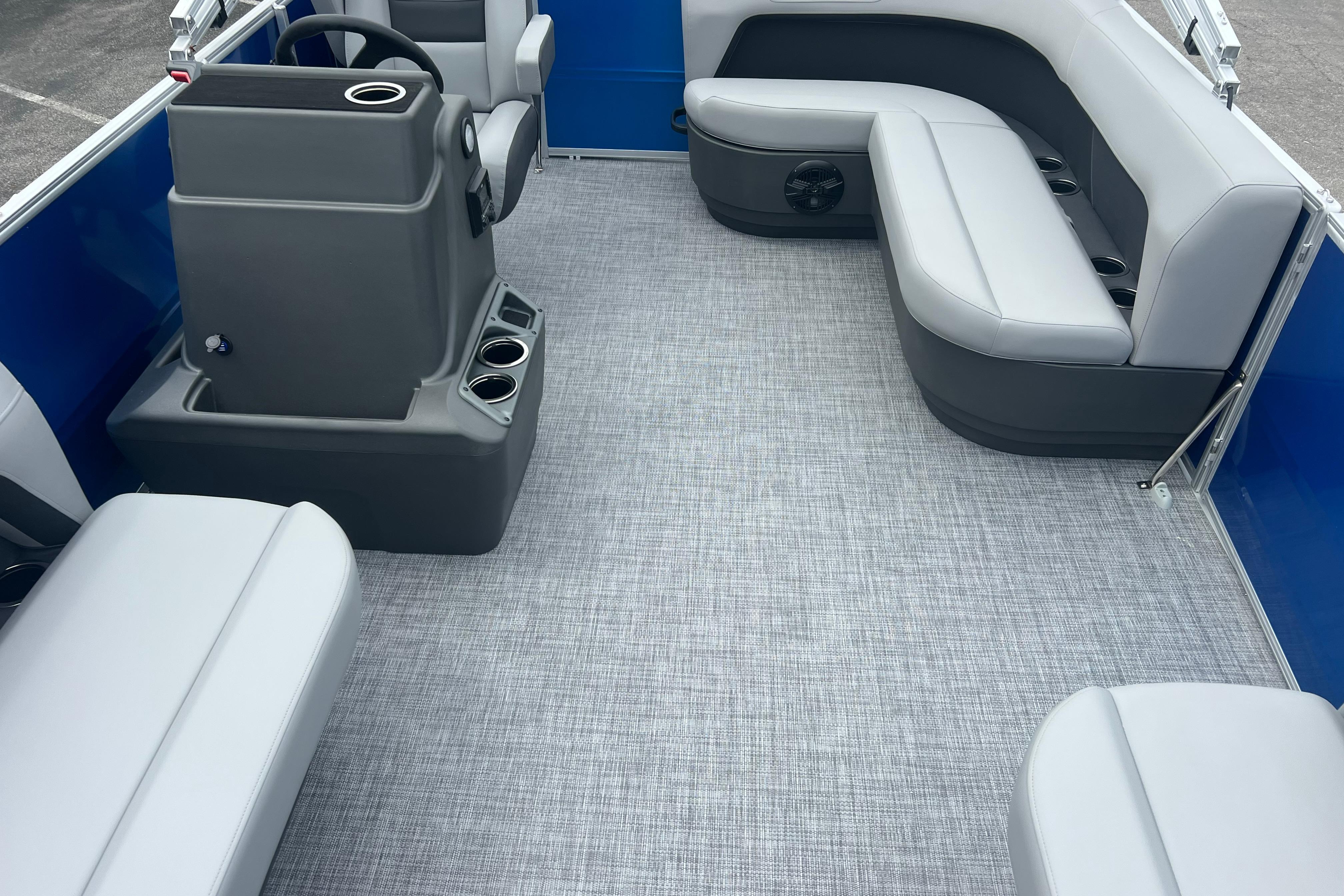 2026 Sun Tracker Party Barge 16 DLX interior with gray seating and modern helm.