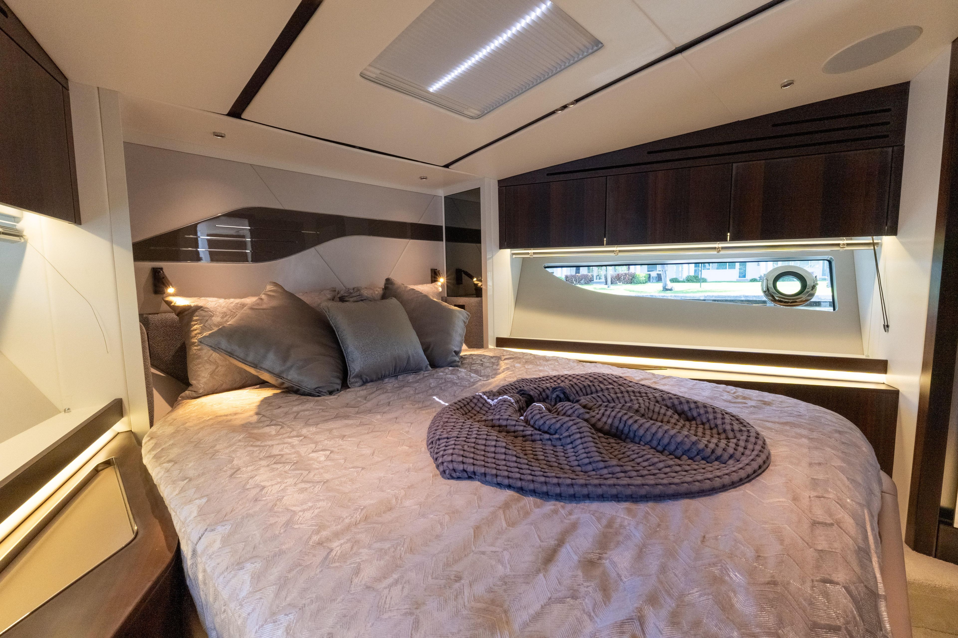Luxurious bedroom interior of 2022 Sunseeker Predator 60 yacht with elegant bedding and modern design.