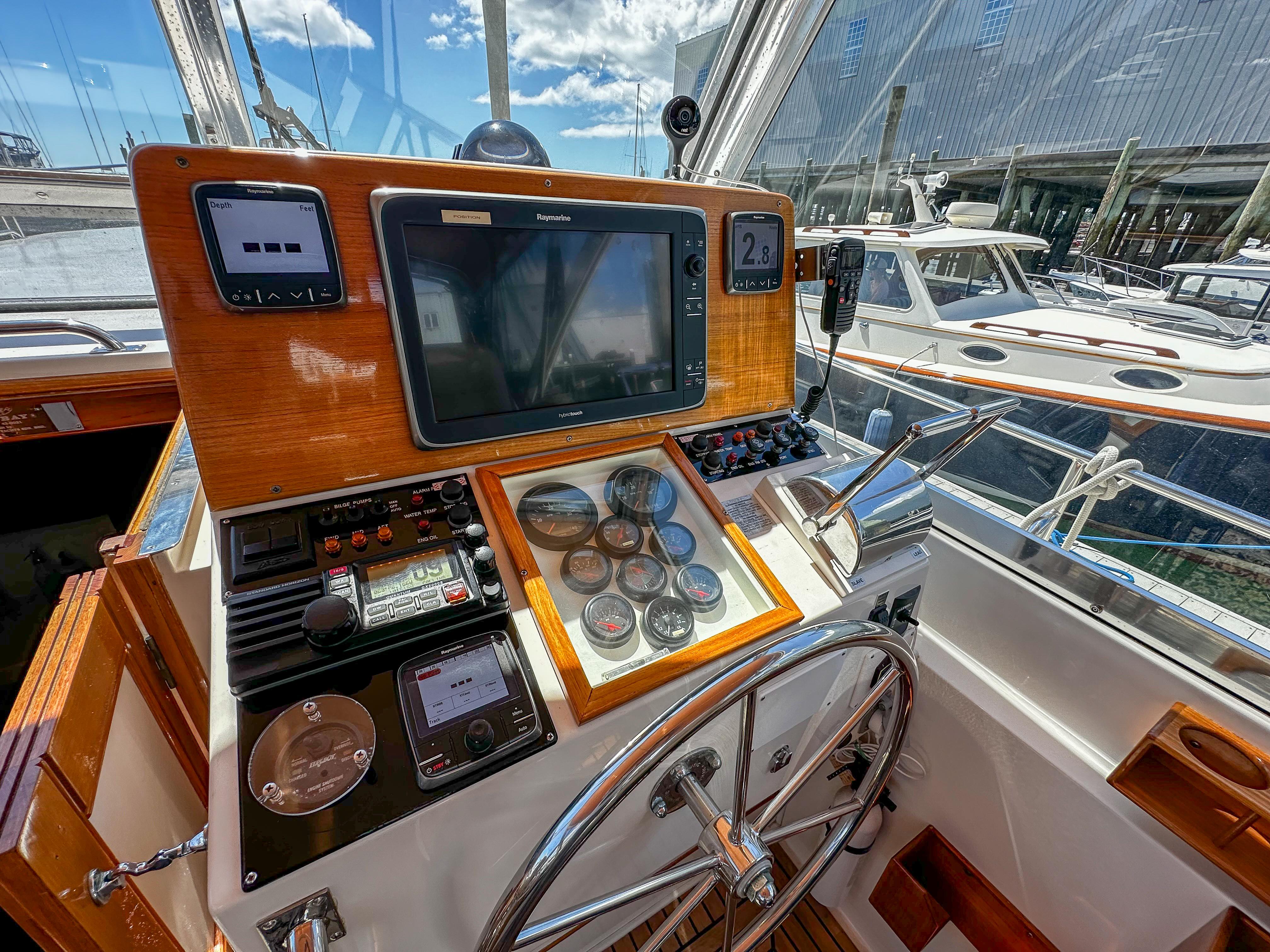 Helm station of 2000 Grand Banks Eastbay 43 Ex with navigation equipment and steering wheel.