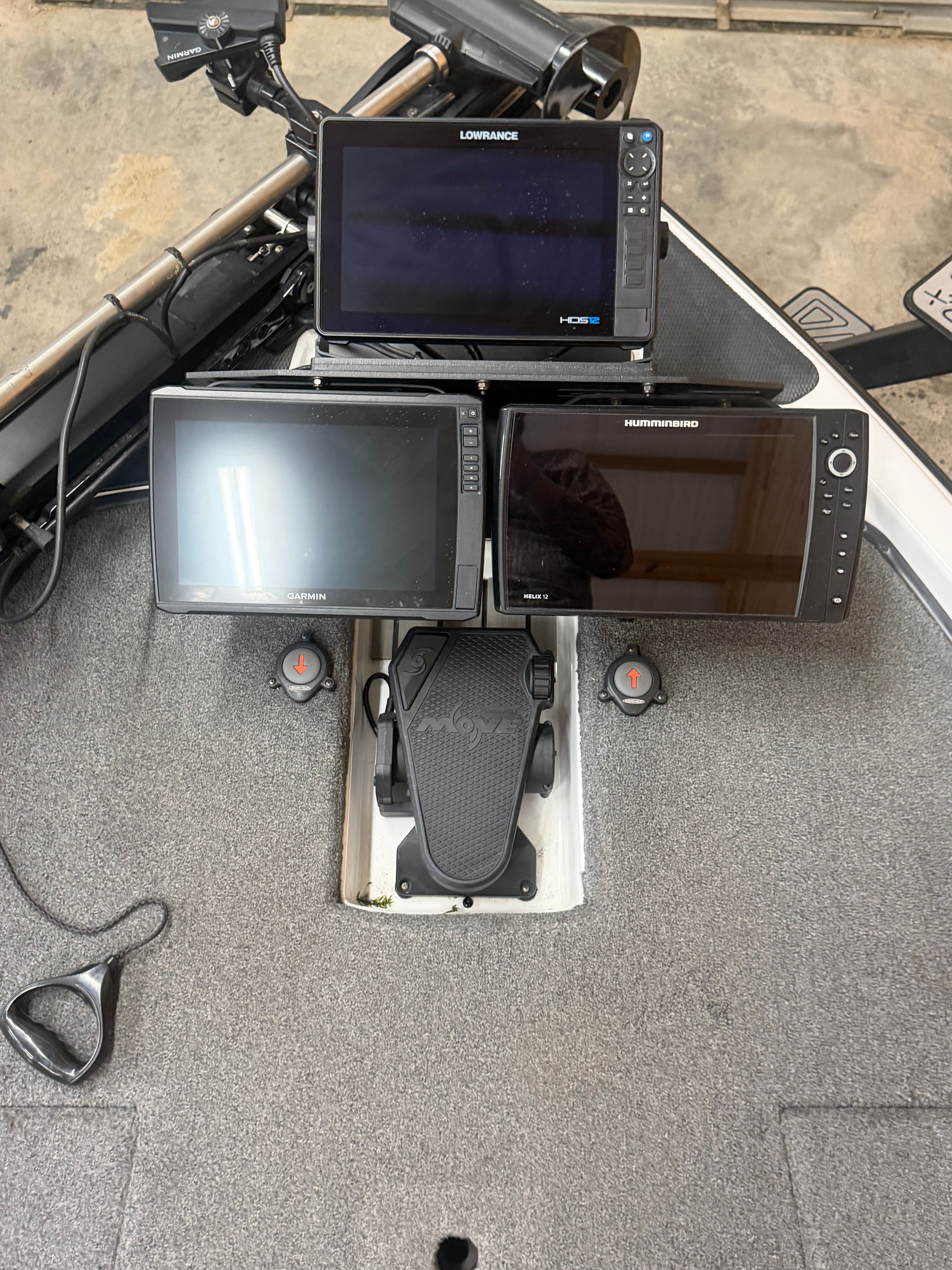 The image shows the cockpit of a Phoenix 920 Elite boat with multiple screens and a pedal.